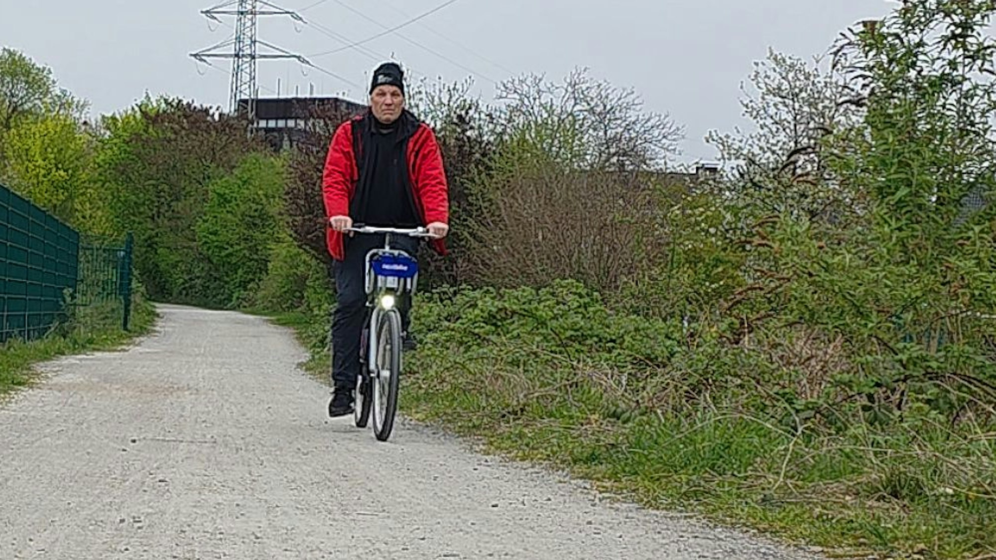 Der Autor des Zeitungsartikels fährt auf einem SEV-Leihfahrrad auf dem ehemaligen Bahndamm der Straßenbahn bei Bergisch Gladbach-Gronau.