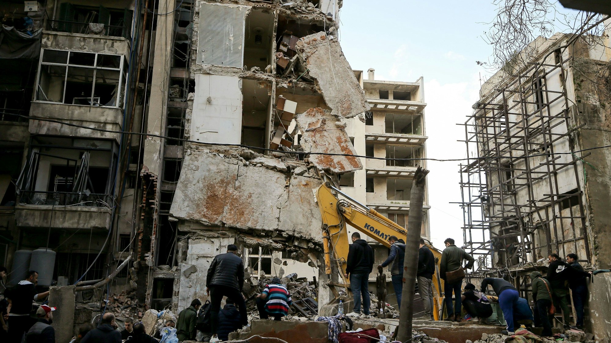 Libanon, Beirut: Anwohner und Mitarbeiter des Zivilschutzes suchen in den Trümmern eines nach einem israelischen Luftangriff eingestürzten Hauses nach Opfern.