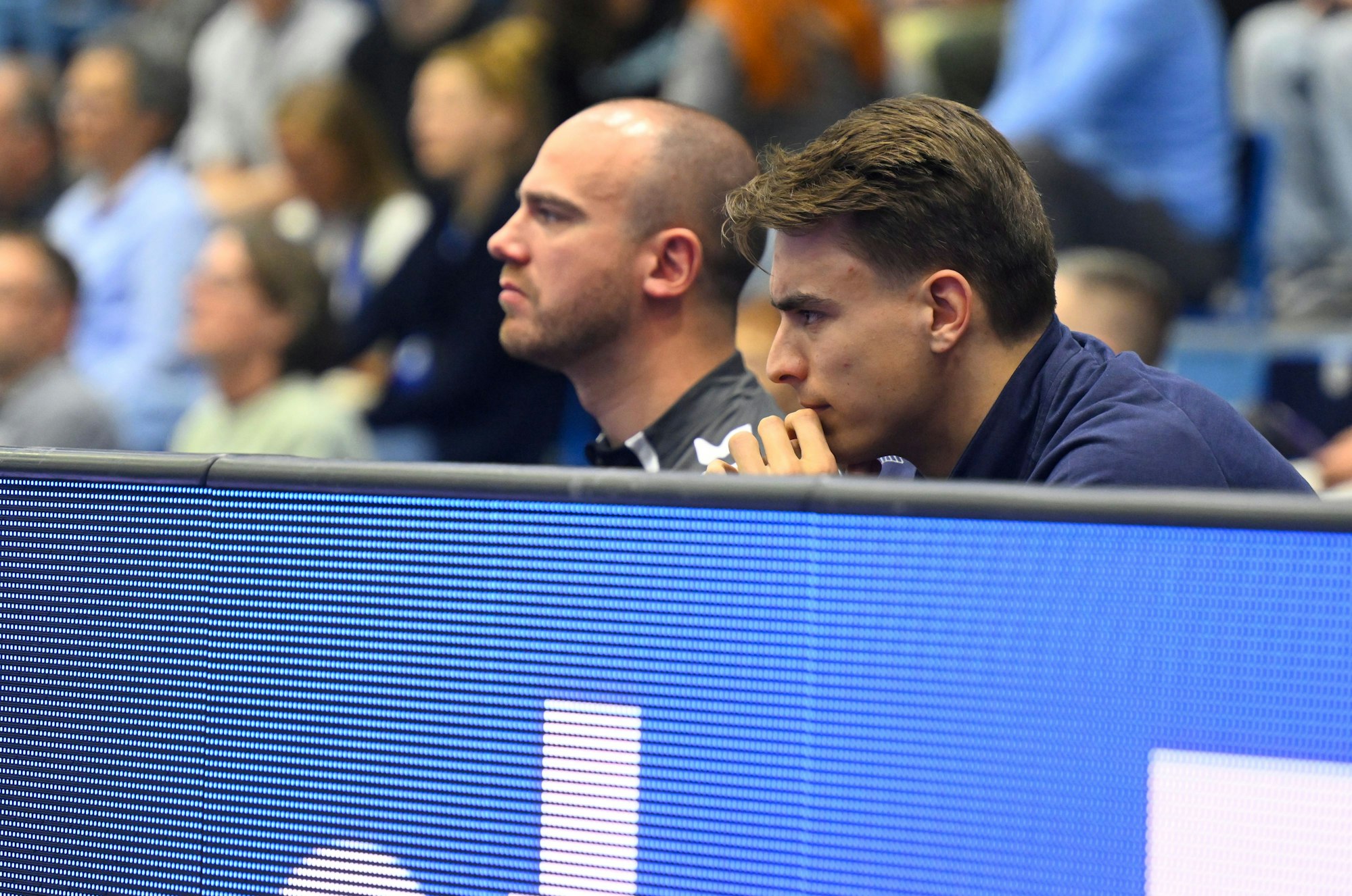 Julian Köster verfolgt hinter der Bande das Bundesligaspiel.