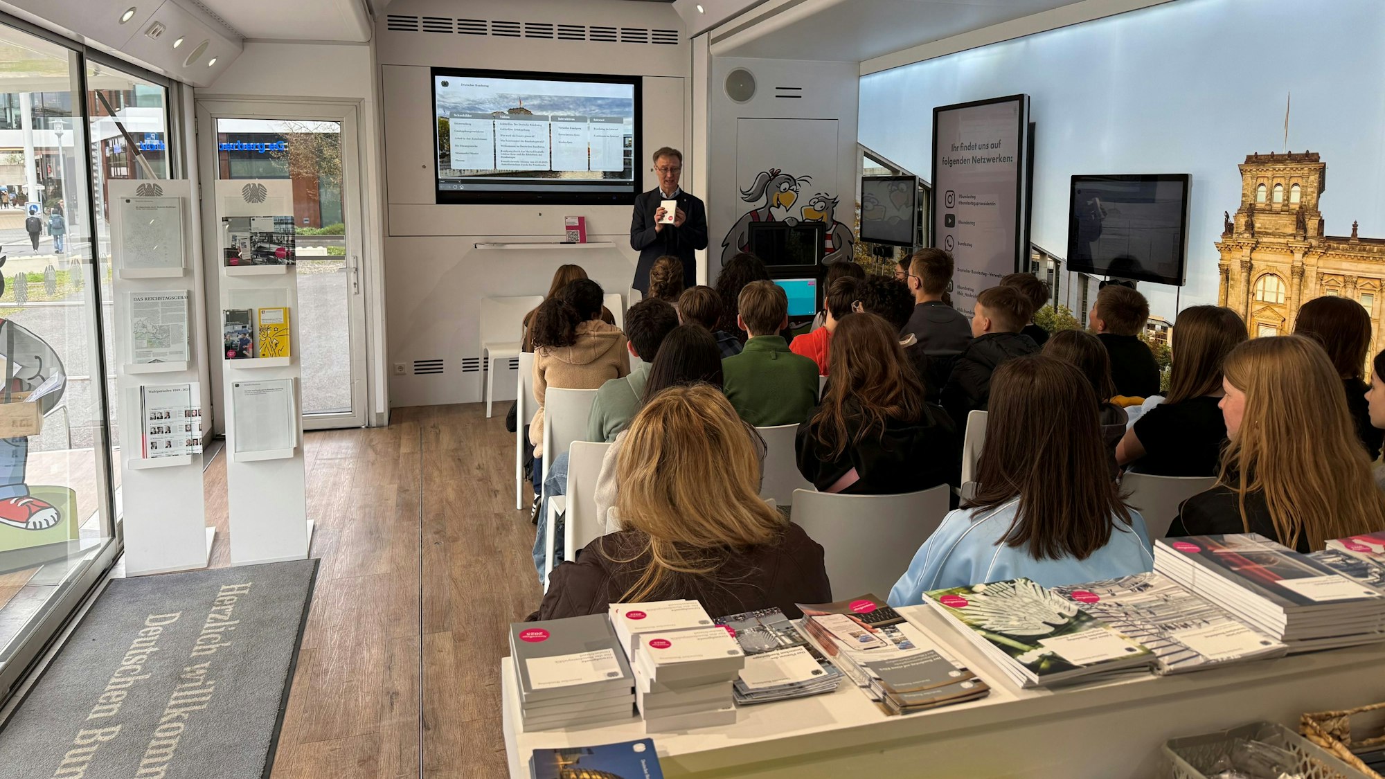 Im Infomobil sitzen die Kinder und hören dem Vortrag von Gunter Smits zu.