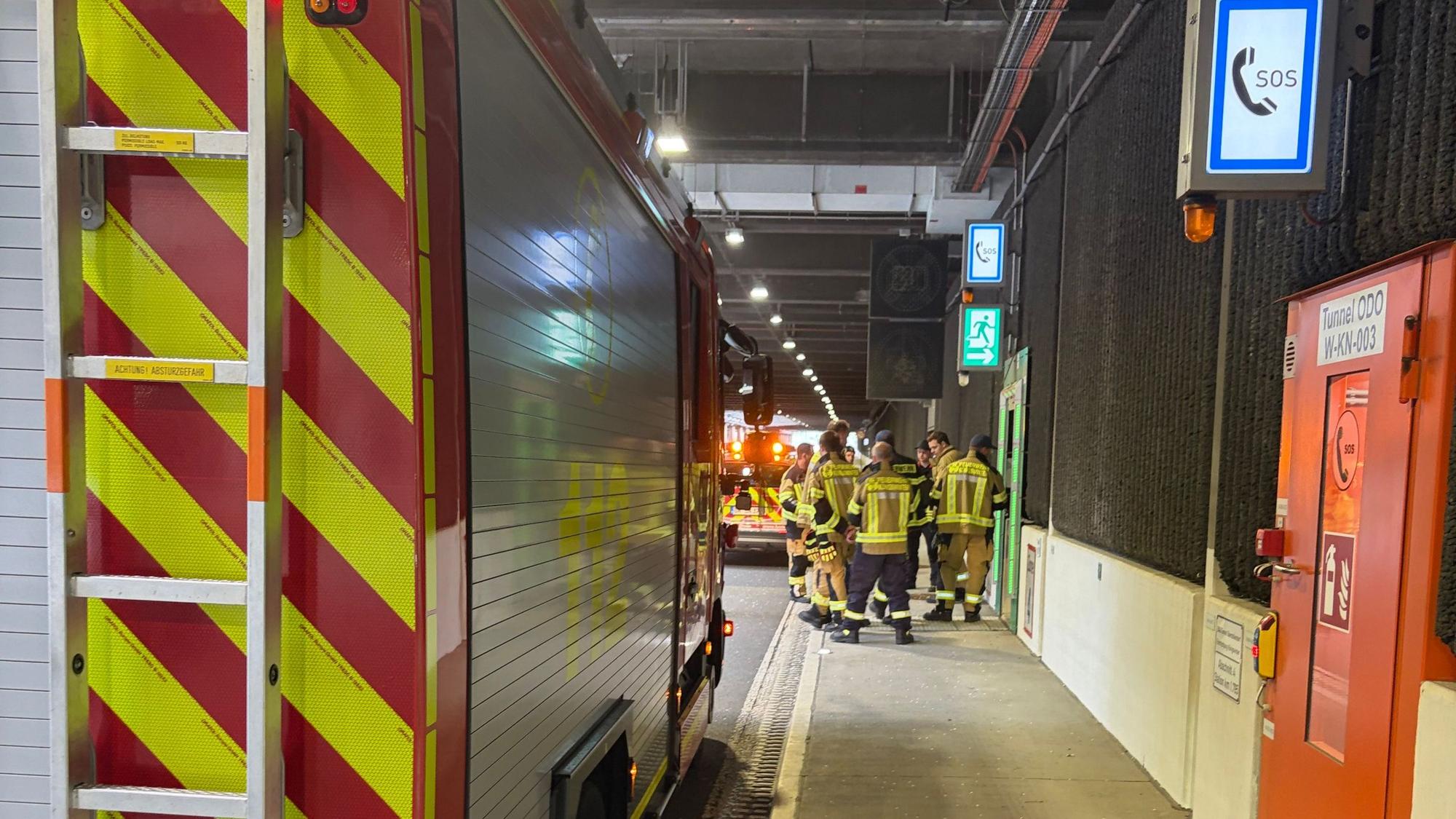 Ein Feuerwehrfahrzeug und Feuerwehrleute in einem Tunnel.
