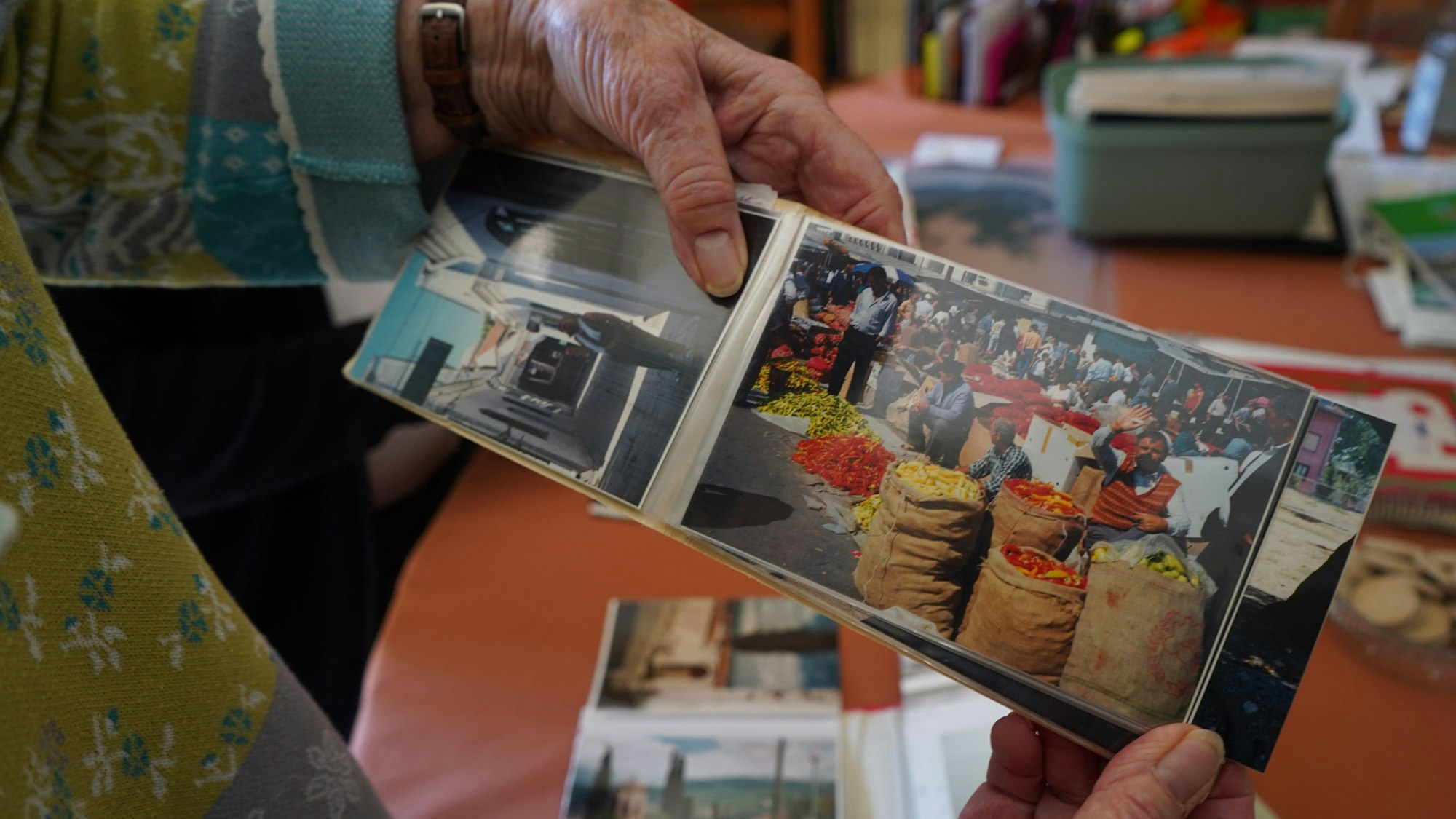Das Foto zeigt ein Fotoalbum, auf einem der Fotos ist ein Markt zu sehen.