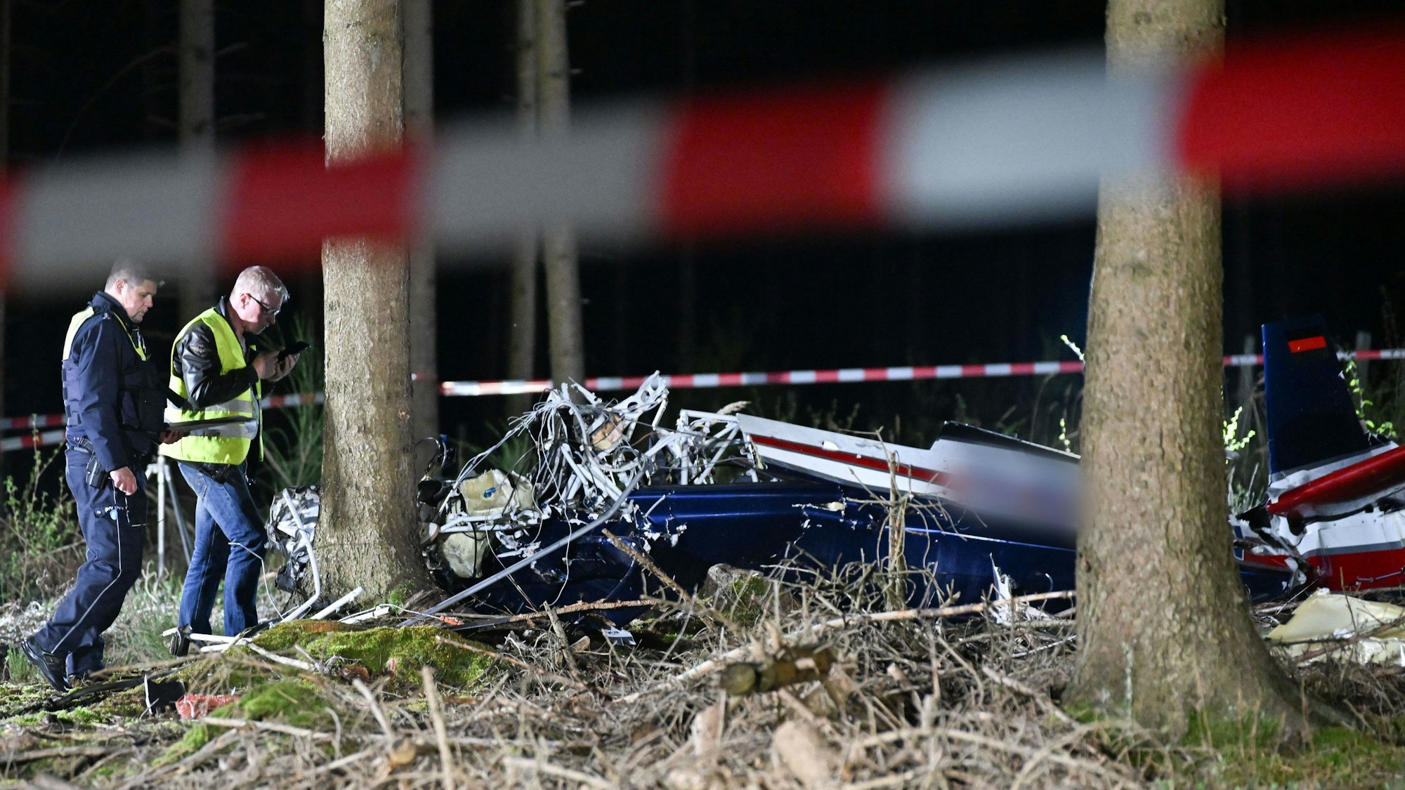 Einsatzkräfte untersuchen ein abgestürztes Kleinflugzeug bei Hürtgenwald. Beim Absturz eines Kleinflugzeugs im Kreis Düren (Nordrhein-Westfalen) sind die beiden Insassen gestorben.