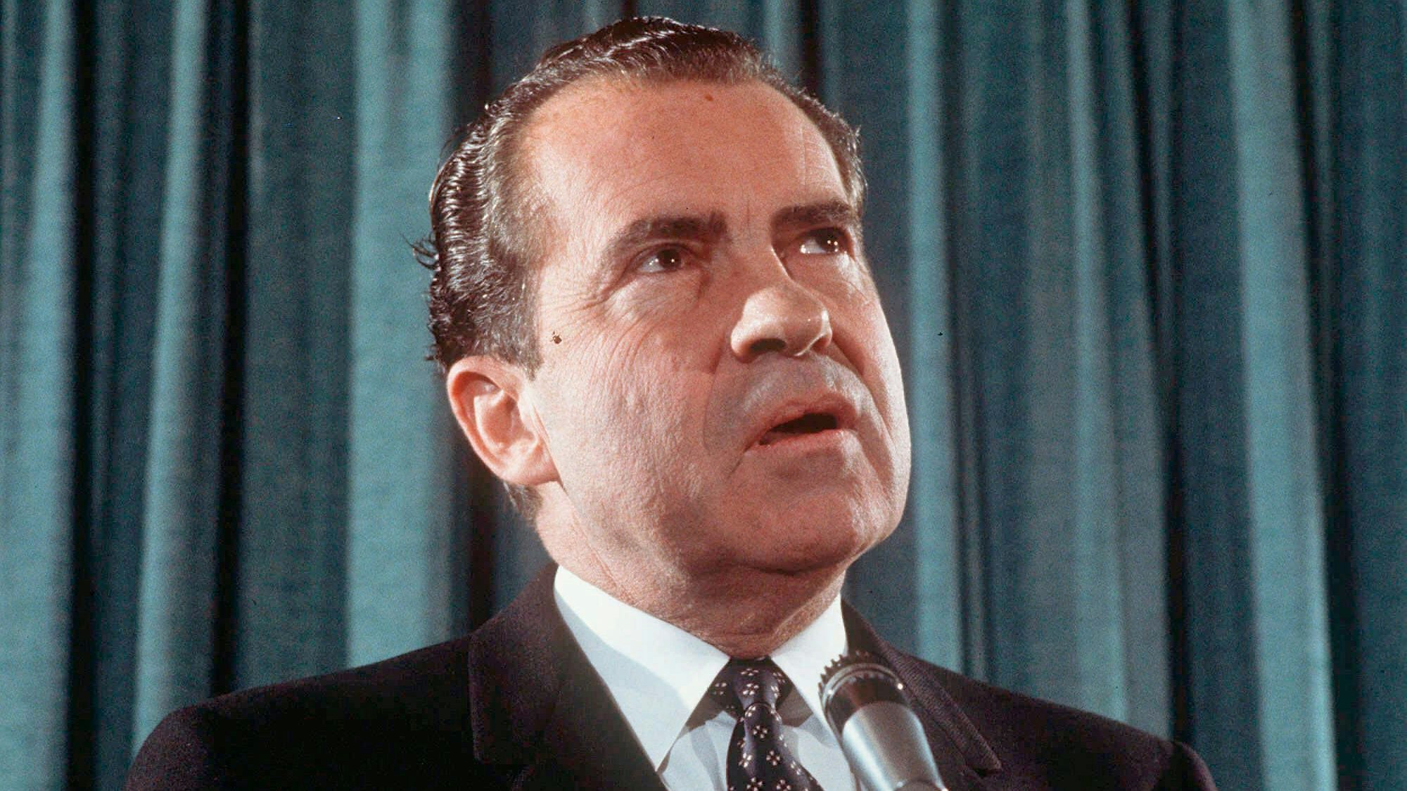 Richard Nixon spricht in ein Mikrofon.