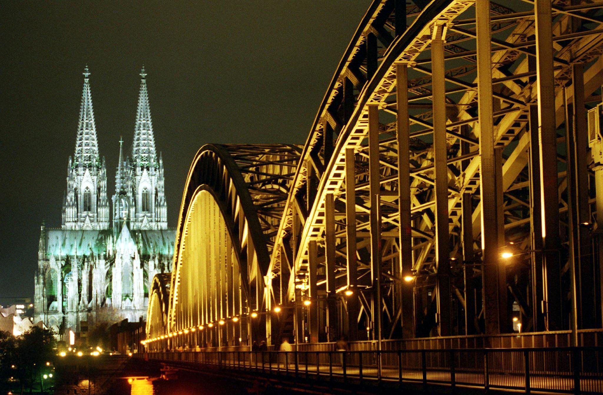 Kölner Dom und Hohenzollernbrücke nachts angestrahlt.