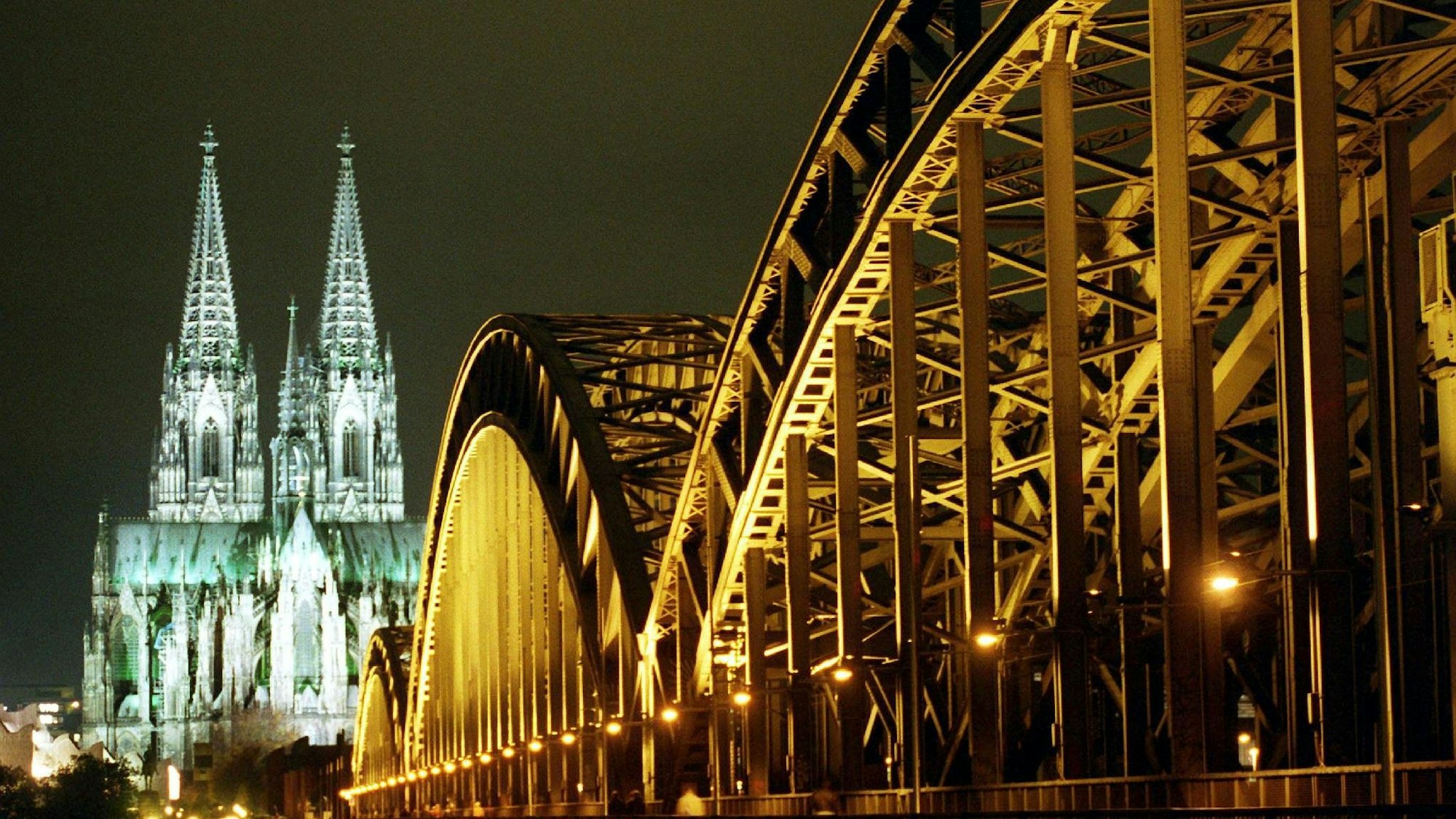 Kölner Dom und Hohenzollernbrücke nachts angestrahlt.