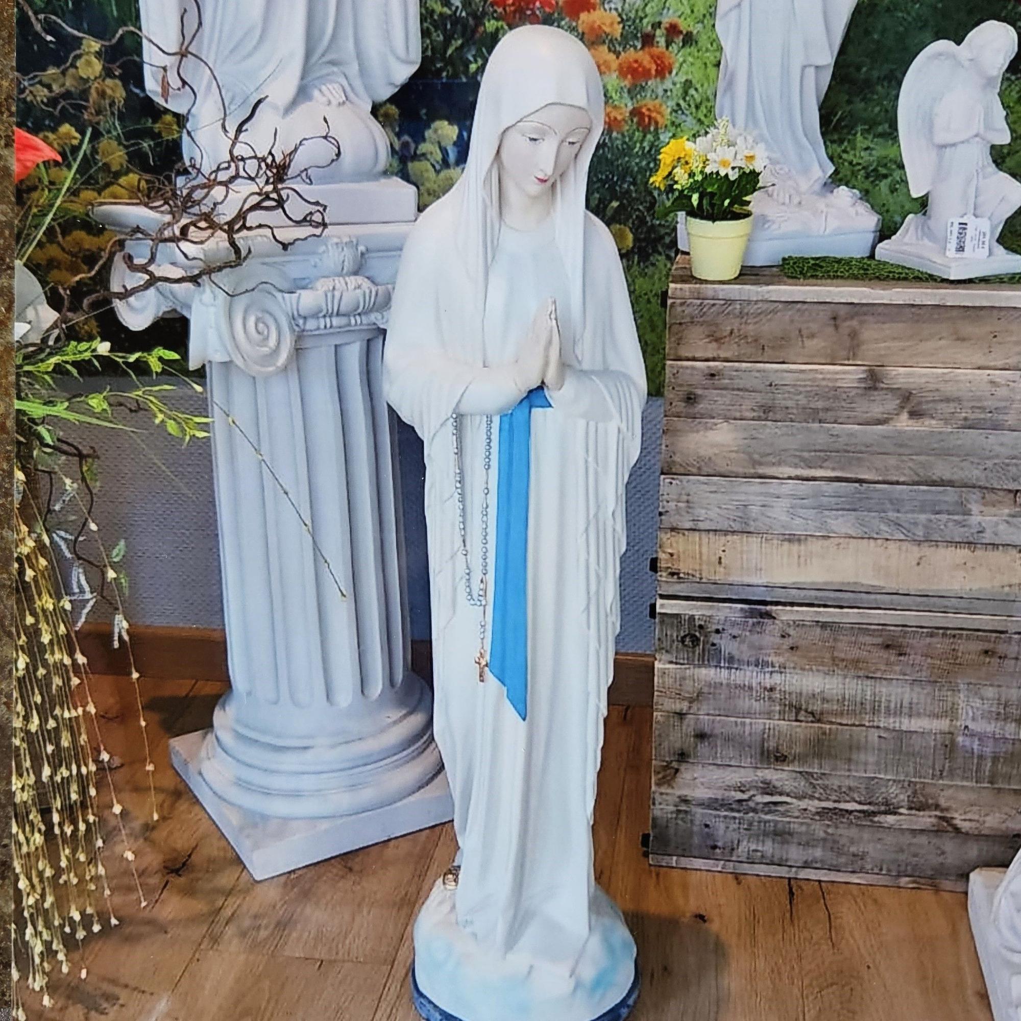 Das Foto zeigt eine weiße Marienfigur mit betenden Händen.