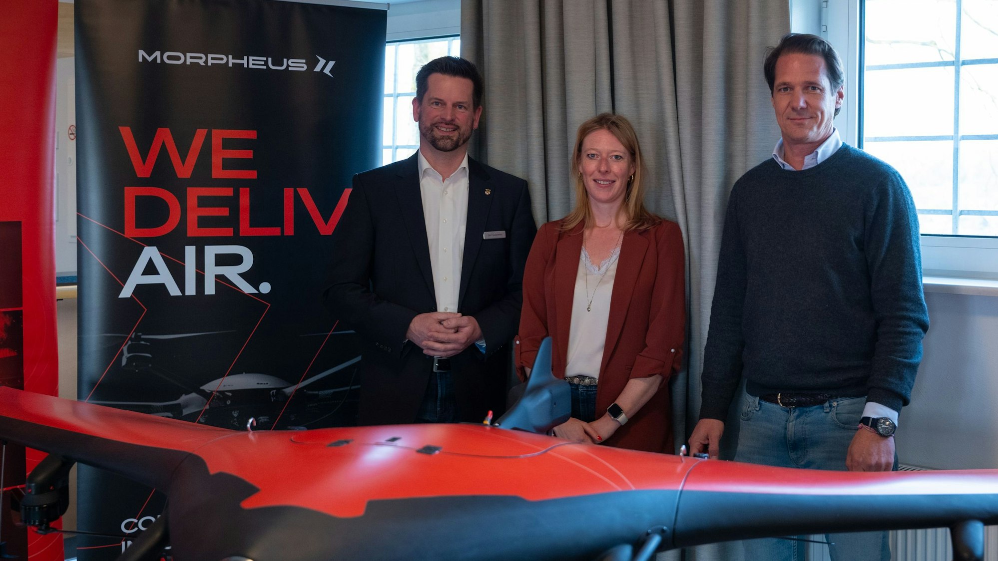 Zu sehen sind drei Menschen hinter einer Drohne, mit der medizinische Drohnenflüge unternommen werden sollen.