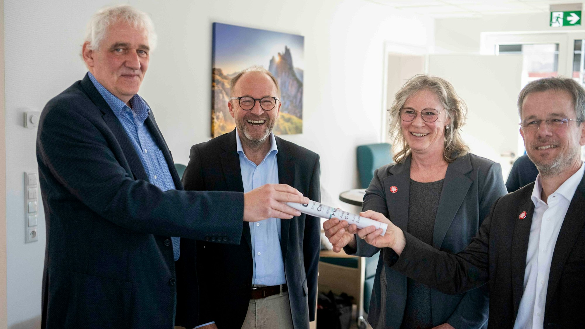 Zwei Vertreter der Firma G&S überreichen die Spende an die beiden Caritasvorstände.