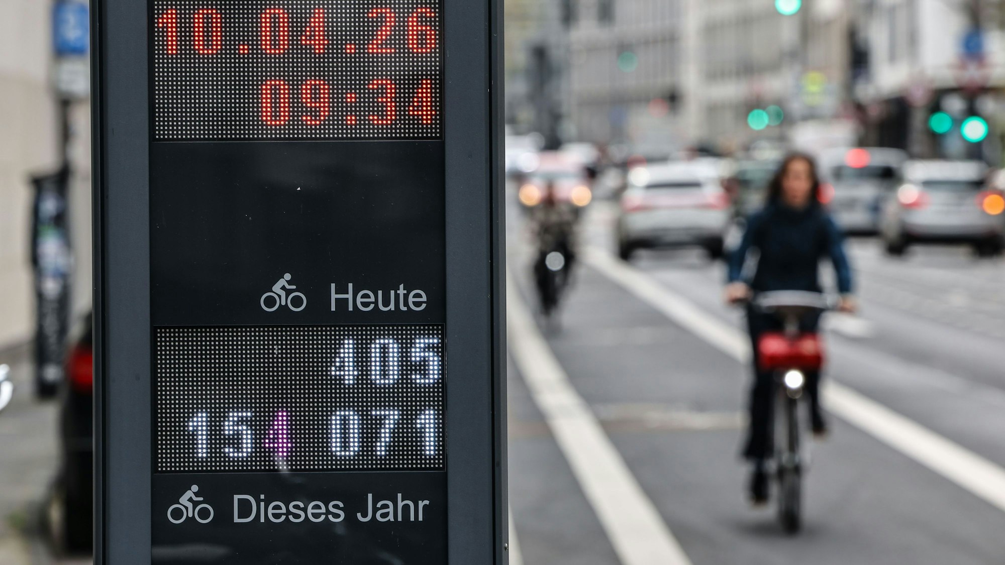 10.04.2026, Nordrhein-Westfalen, Köln: Eine Radfahrerin fährt in der Innenstadt an einer Dauerzählstelle vorbei, die die Nutzung der Radwege und Radspuren erfassen. Die Landesregierung in Nordrhein-Westfalen plant 1.000 Kilometer neue Radwege zu bauen. Foto: Oliver Berg/dpa +++ dpa-Bildfunk +++