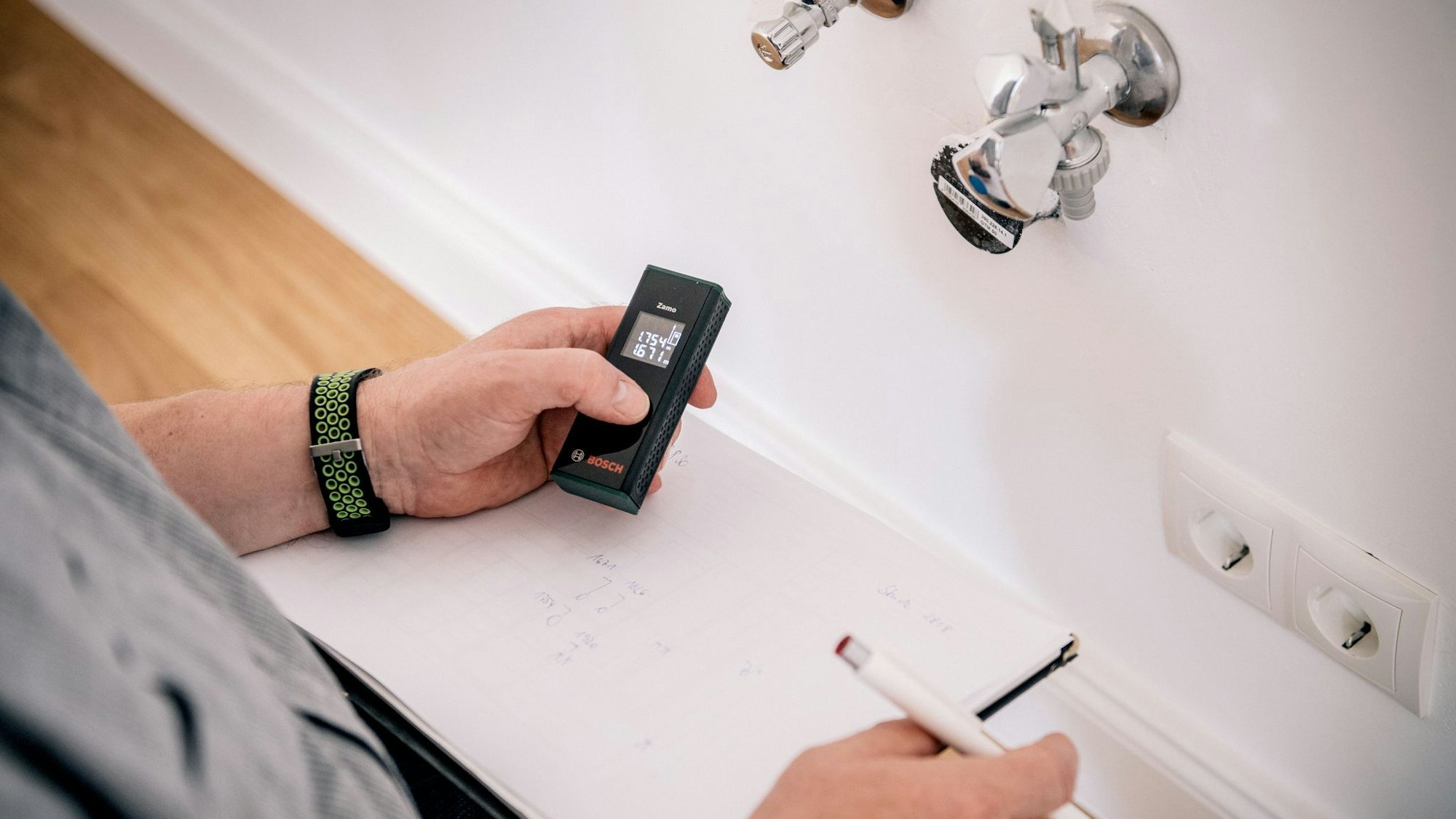 Küchenplaner nimmt Aufmaß mit Laser-Entfernungsmessgerät