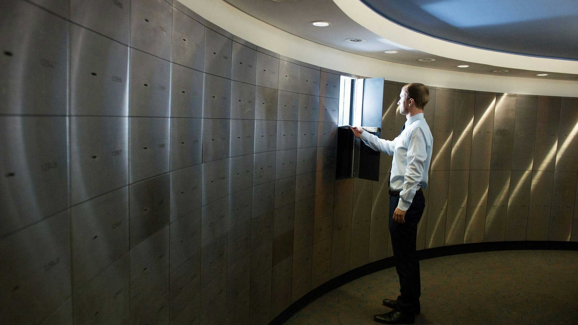 Ein Sparkassenmitarbeiter legt Papiere in ein Schließfach