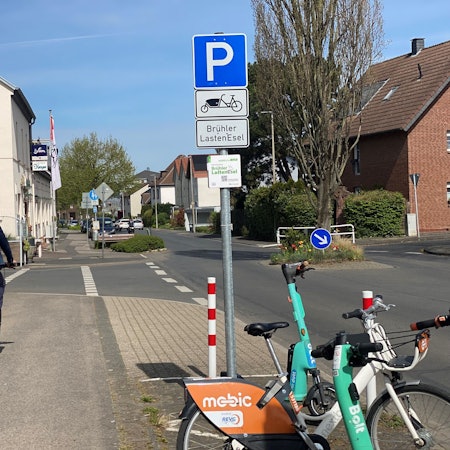 Zu sehen ist ein Radler, der entlang einer Straße fährt.