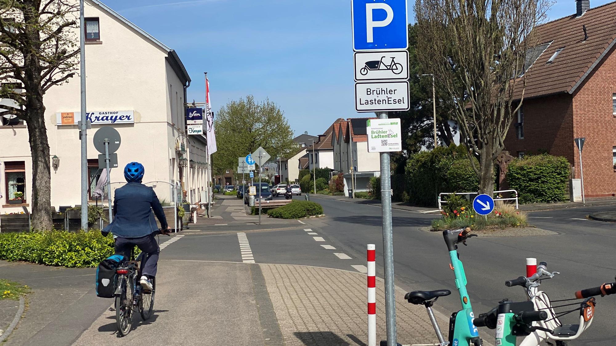 Zu sehen ist ein Radler, der entlang einer Straße fährt.
