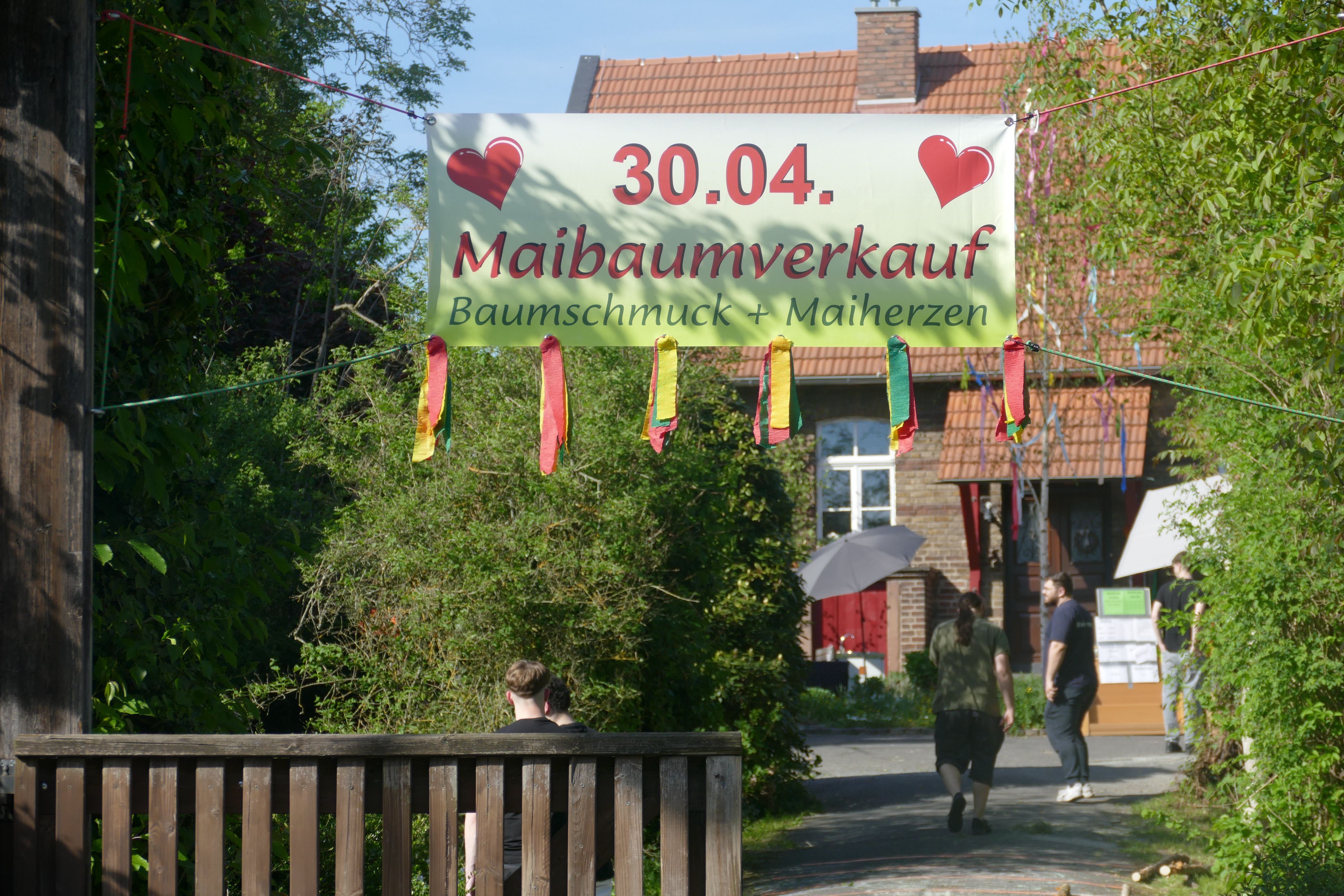 Ein Werbetransparent für den Verkauf von Maibäumen.