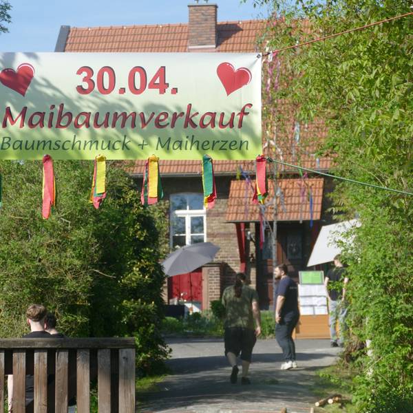 Ein Werbetransparent für den Verkauf von Maibäumen.