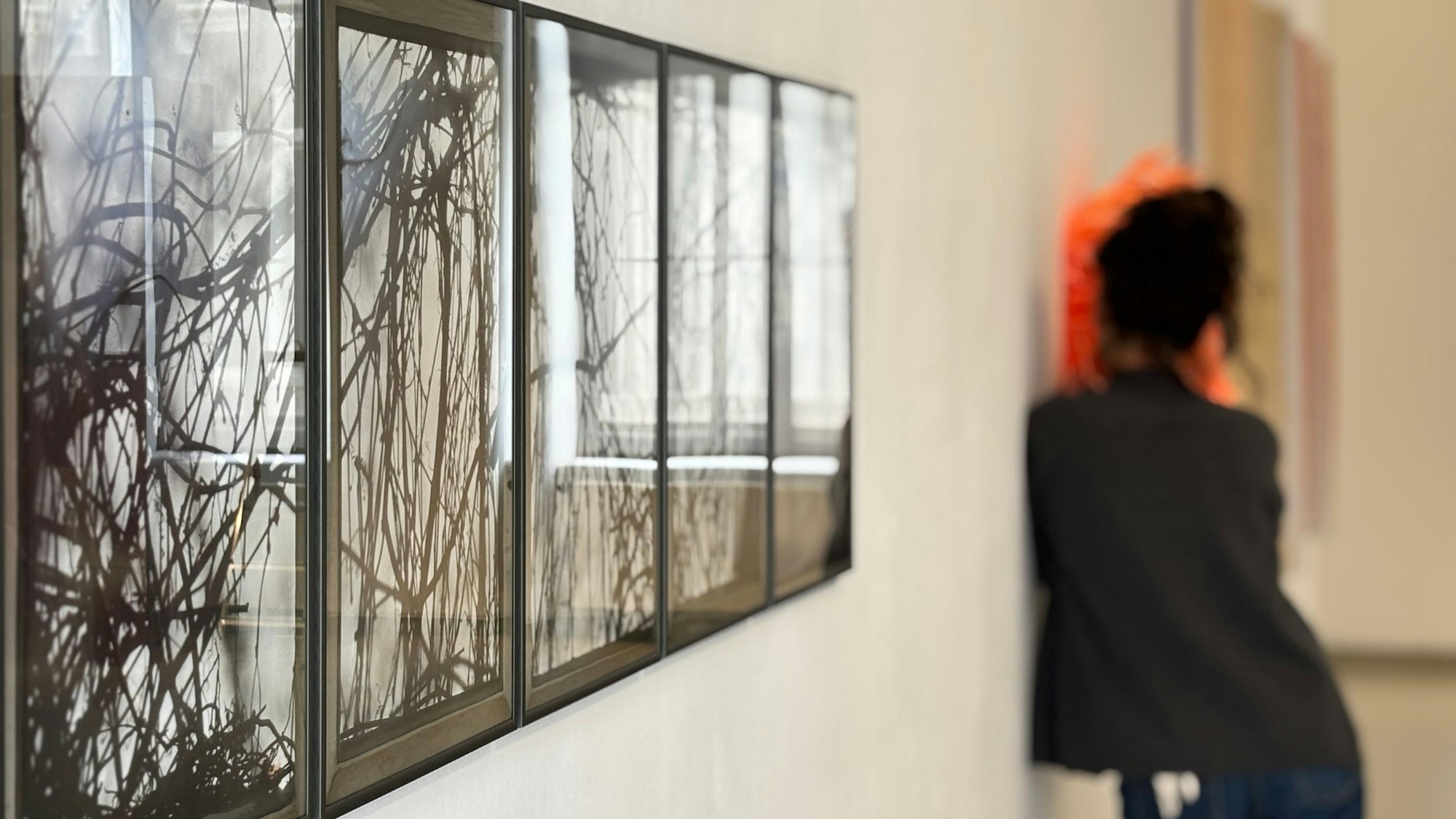 Künstlerin Ute Bartel richtet im Hintergrund eine Installation her, die in den Raum hereinragt.