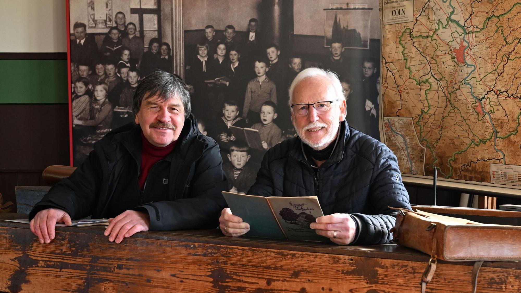 Michael Kamp (l.) und Werner Hütt, Geschäftsführer des Vereins der Freunde und Förderer des Freilichtmuseums Lindlar in einer Schulbank der ehemaligen Elementarschule Hermesdorf.