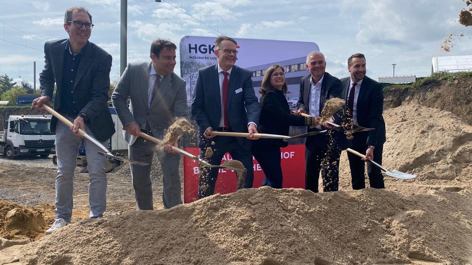 Zu sehen ist eine Gruppe von Menschen, die Spaten in den Händen halten.