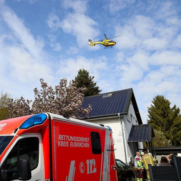 Der ADAC-Rettungshubschrauber fliegt über das Haus, davor ein Rettungswagen und Einsatzkräfte.