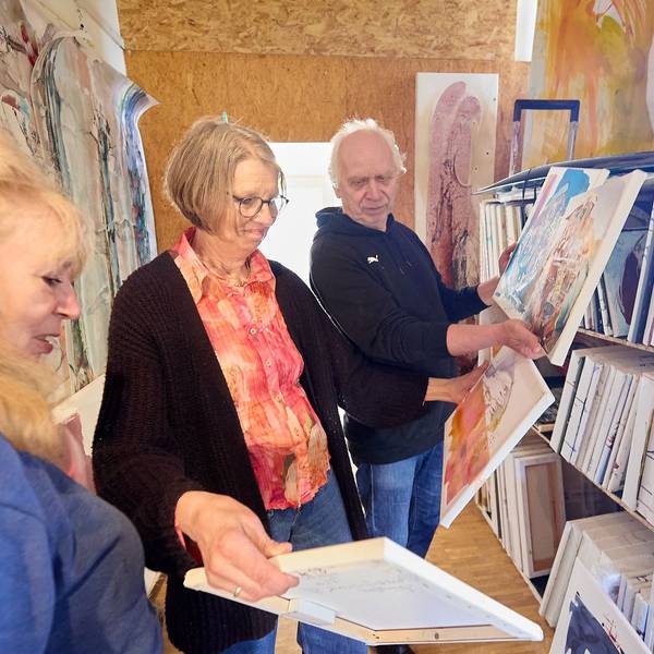 Gundolf und Marianne Roy und Maf Räderscheidt (v.r.n.l.) schauen sich in einem Atelier Gemälde an.