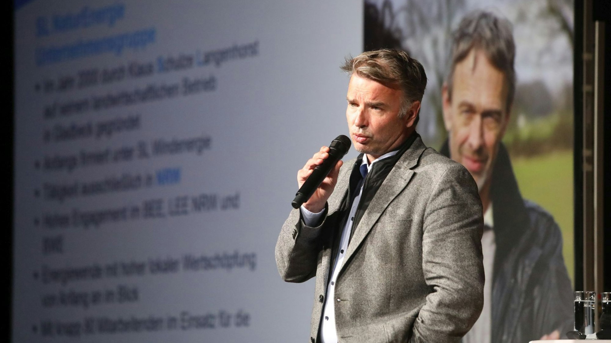 Ein Mann mit einem Mikrofon in der Hand.