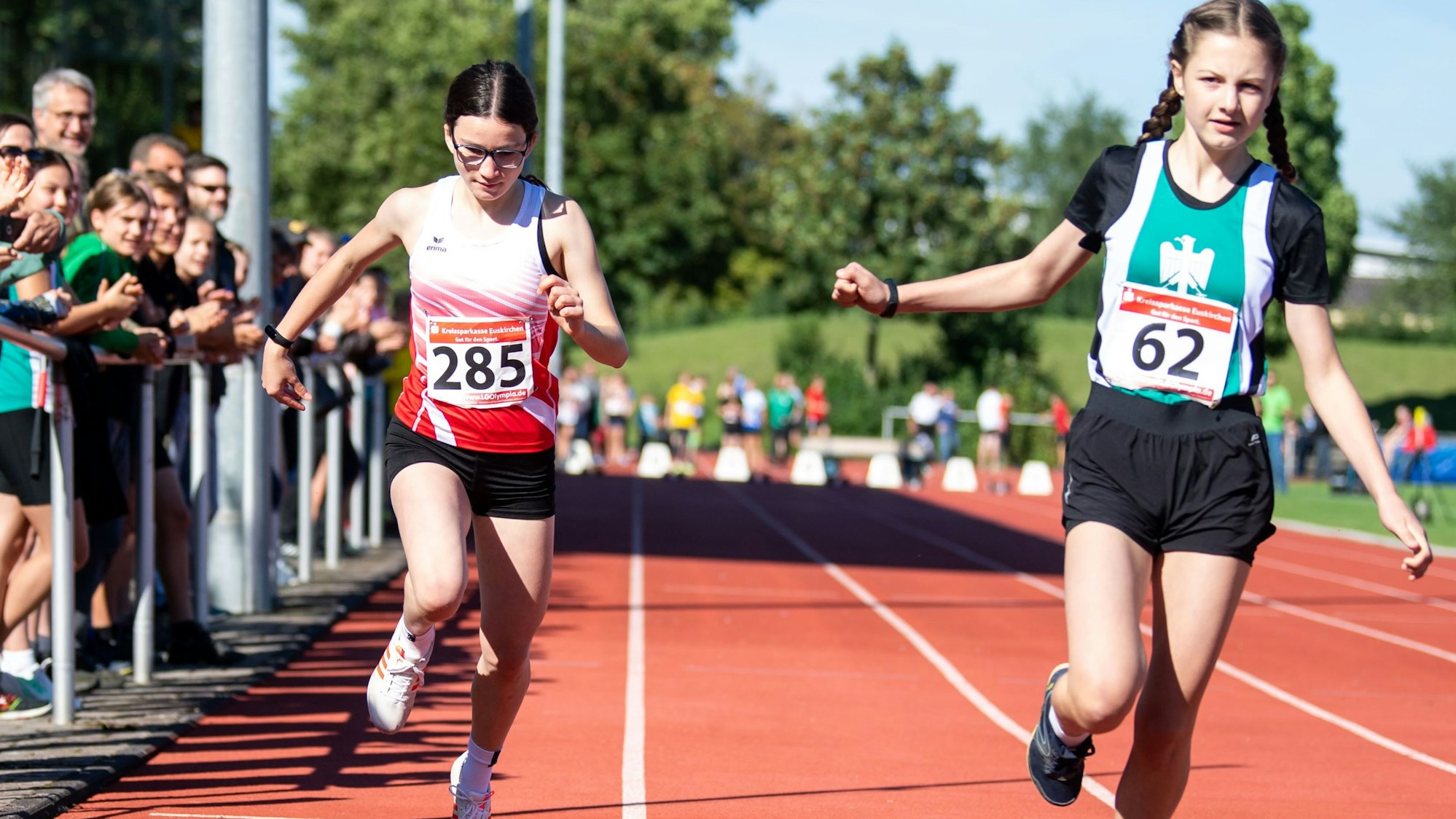 Das Bild zeigt zwei Nachwuchsläuferinnen, während sie die Ziellinie überqueren.