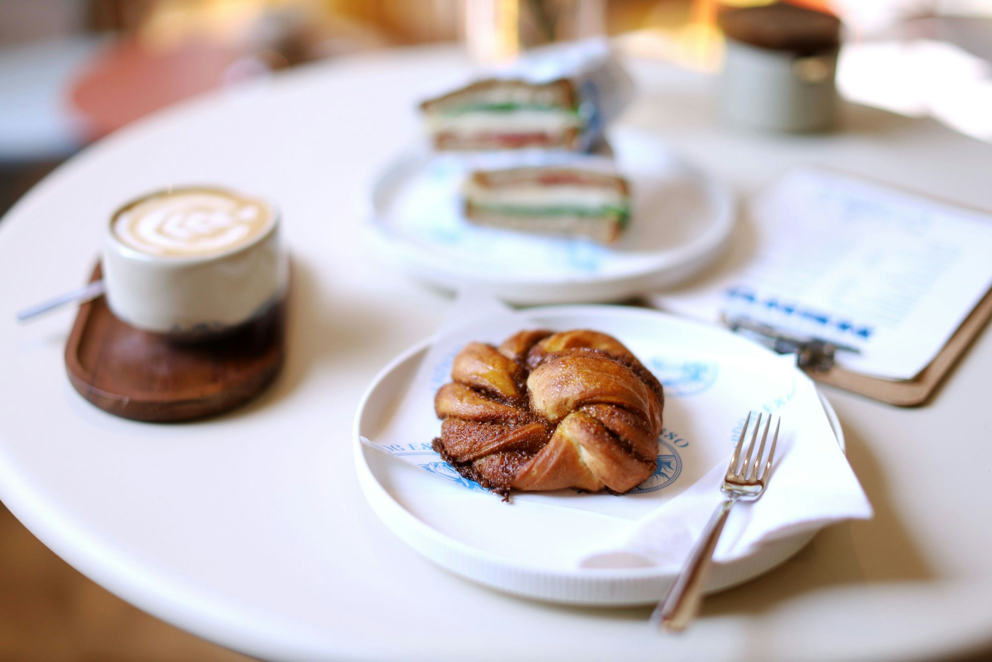 Gedeckter Tisch mit Kaffee, einem Gebächstück und Sandwiches ist zu sehen.