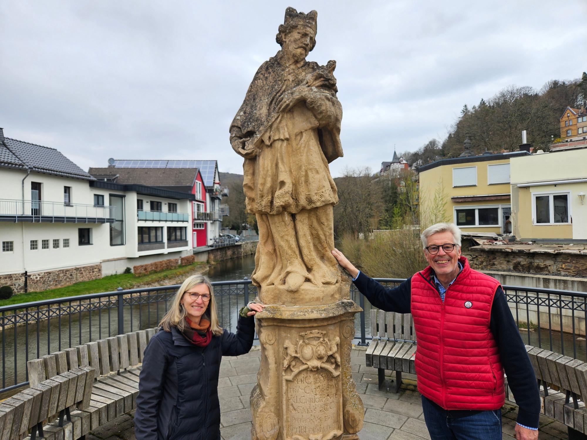 Susanne Hahn und Dr. Klaus Duck stehen links und rechts neben der Nepomuk-Figur.