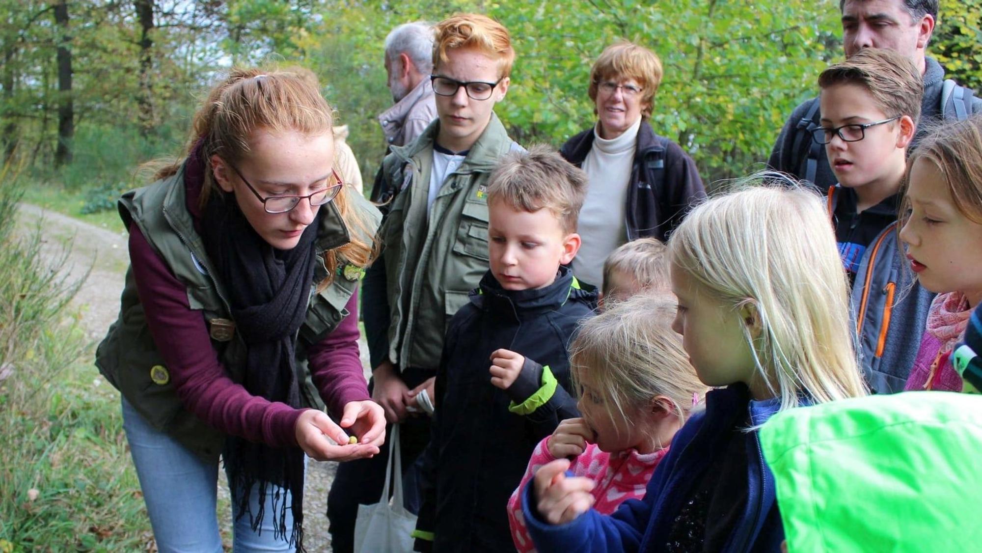 Eine Juniorrangerin des Nationlaparks mit einer Besuchergruppe, darunter zahlreiche Kinder.