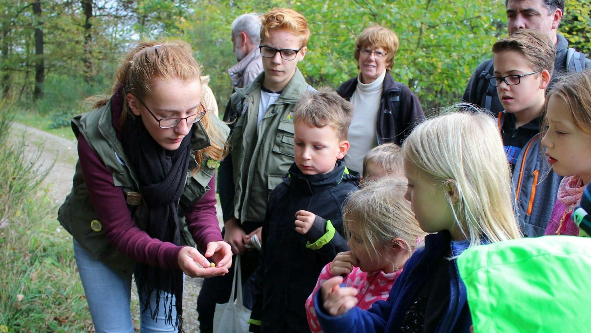 Eine Juniorrangerin des Nationlaparks mit einer Besuchergruppe, darunter zahlreiche Kinder.