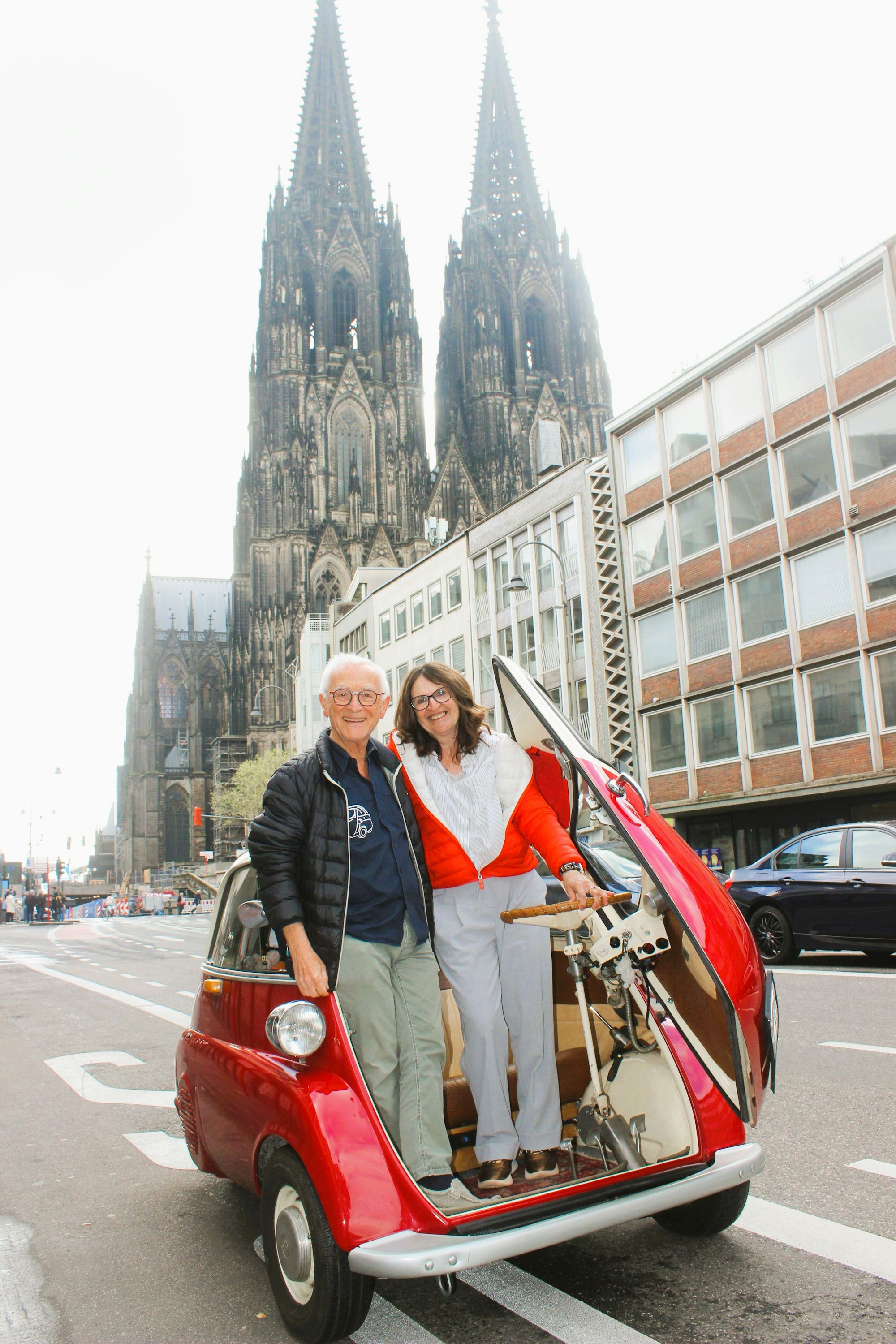 Die Schmidts mit ihrem BMW Isetta vor dem Dom