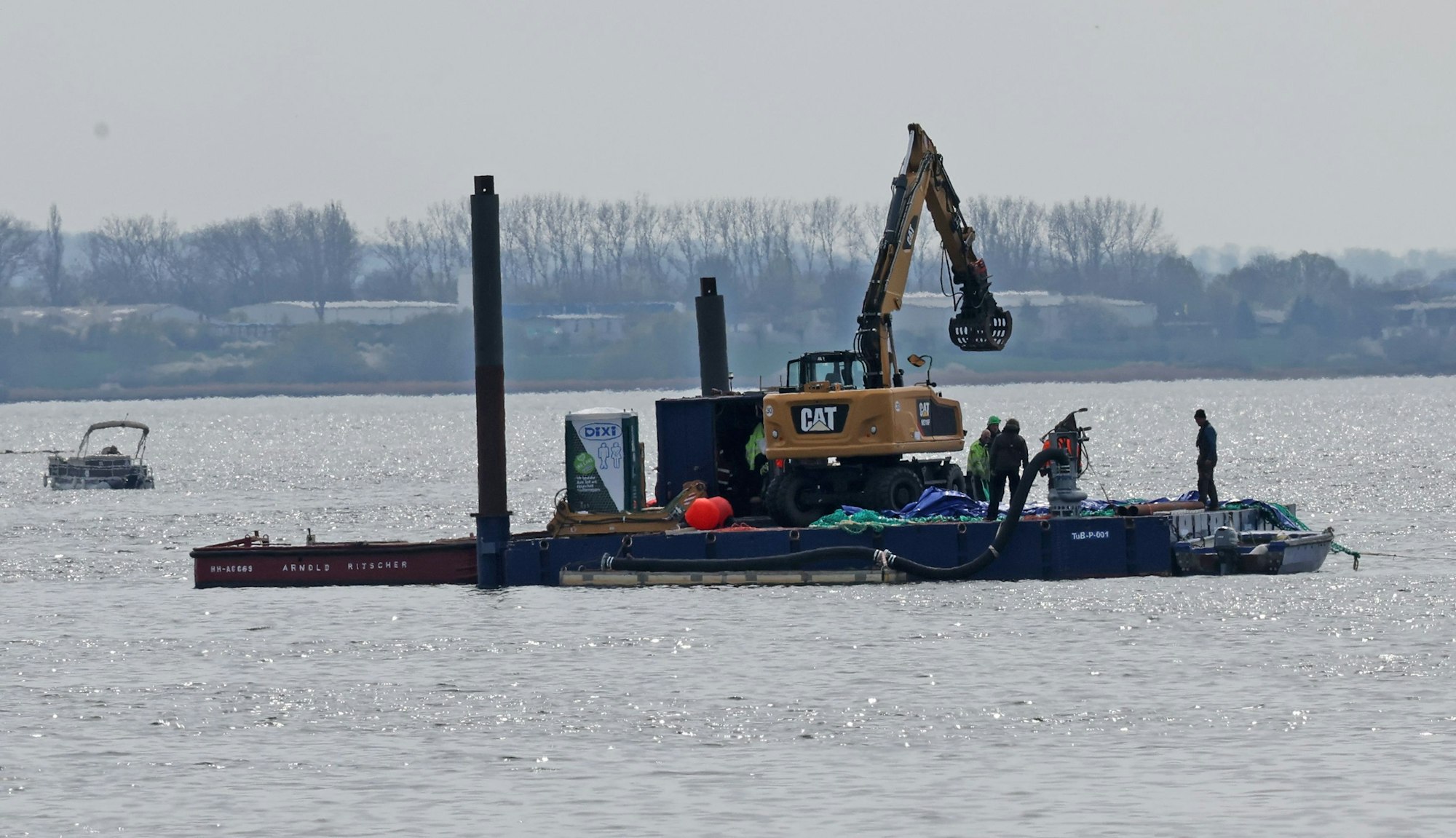 Ein Arbeitsponton mit einem speziellen Bagger und kleinere Begleitboote sind in der Nähe des gestrandeten Buckelwals vor der Insel Poel im Einsatz.