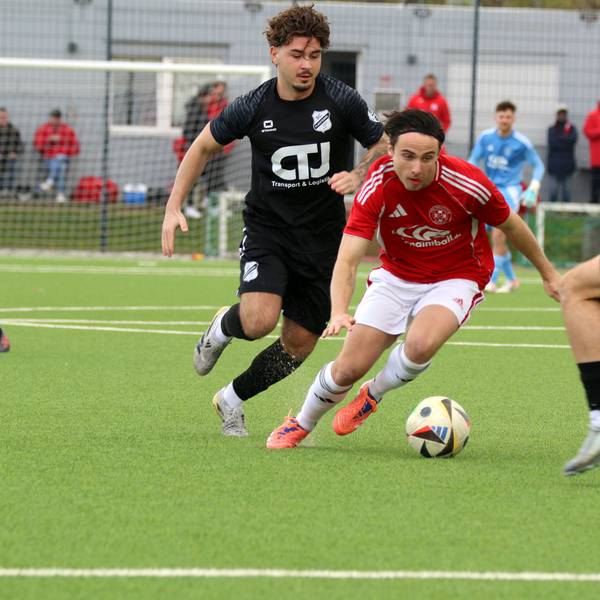 Marlon Große führt den Ball in gebückter Haltung zwischen zwei Gegenspielern hindurch.
