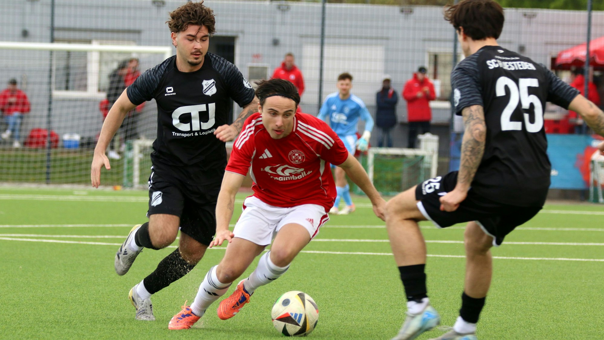 Marlon Große führt den Ball in gebückter Haltung zwischen zwei Gegenspielern hindurch.