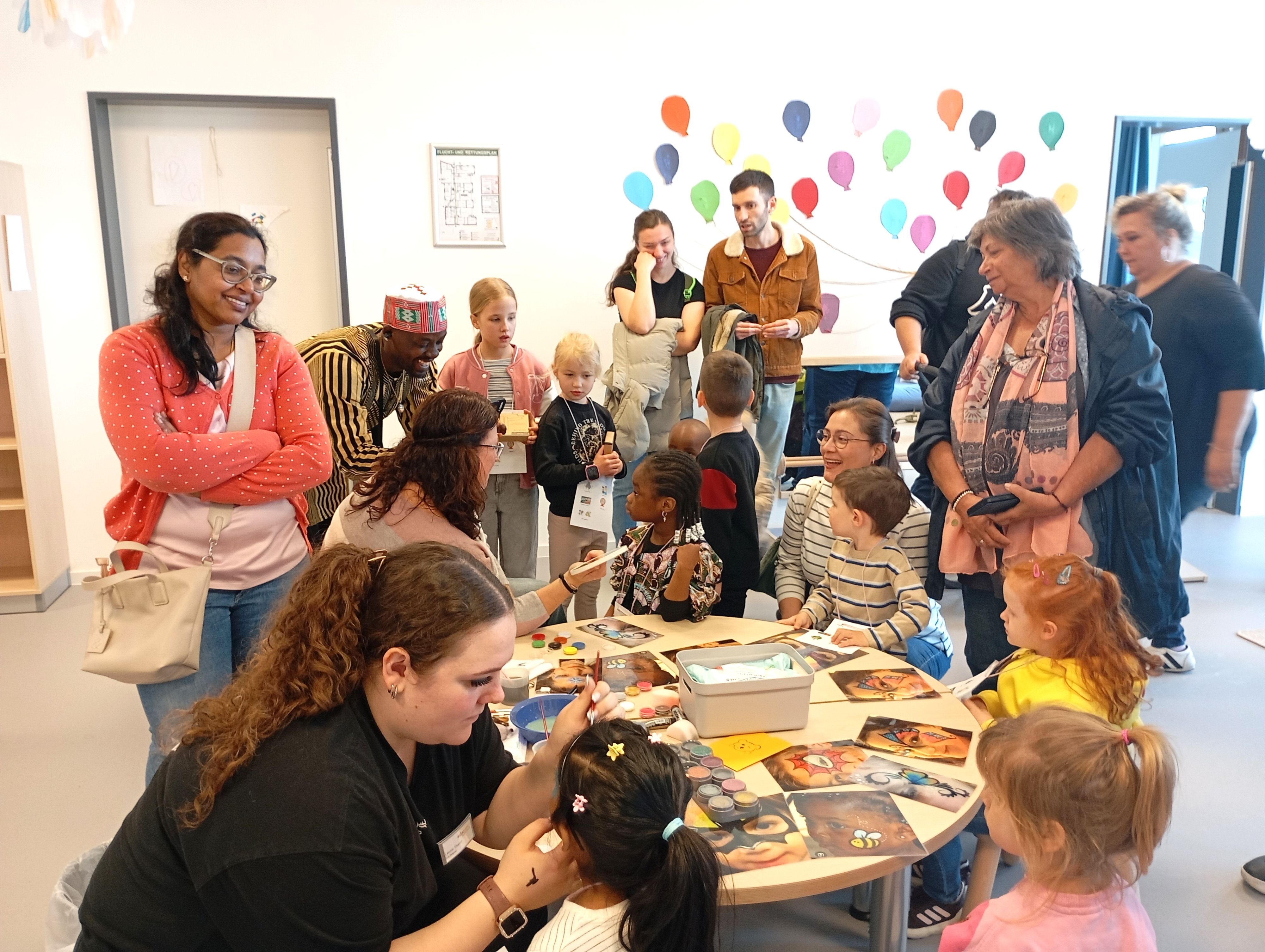 Zu sehen sind Frauen, die Kinder schminken.