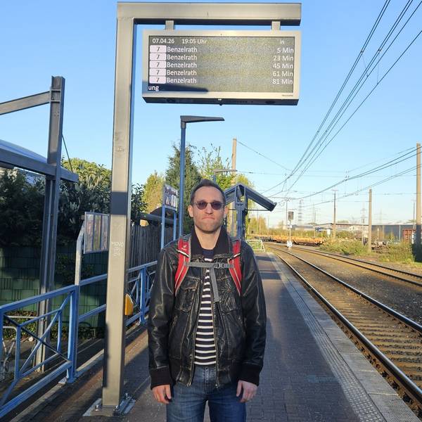 Das Bild zeigt den Fahrgast an der Haltestelle, die Gleise neben sich.