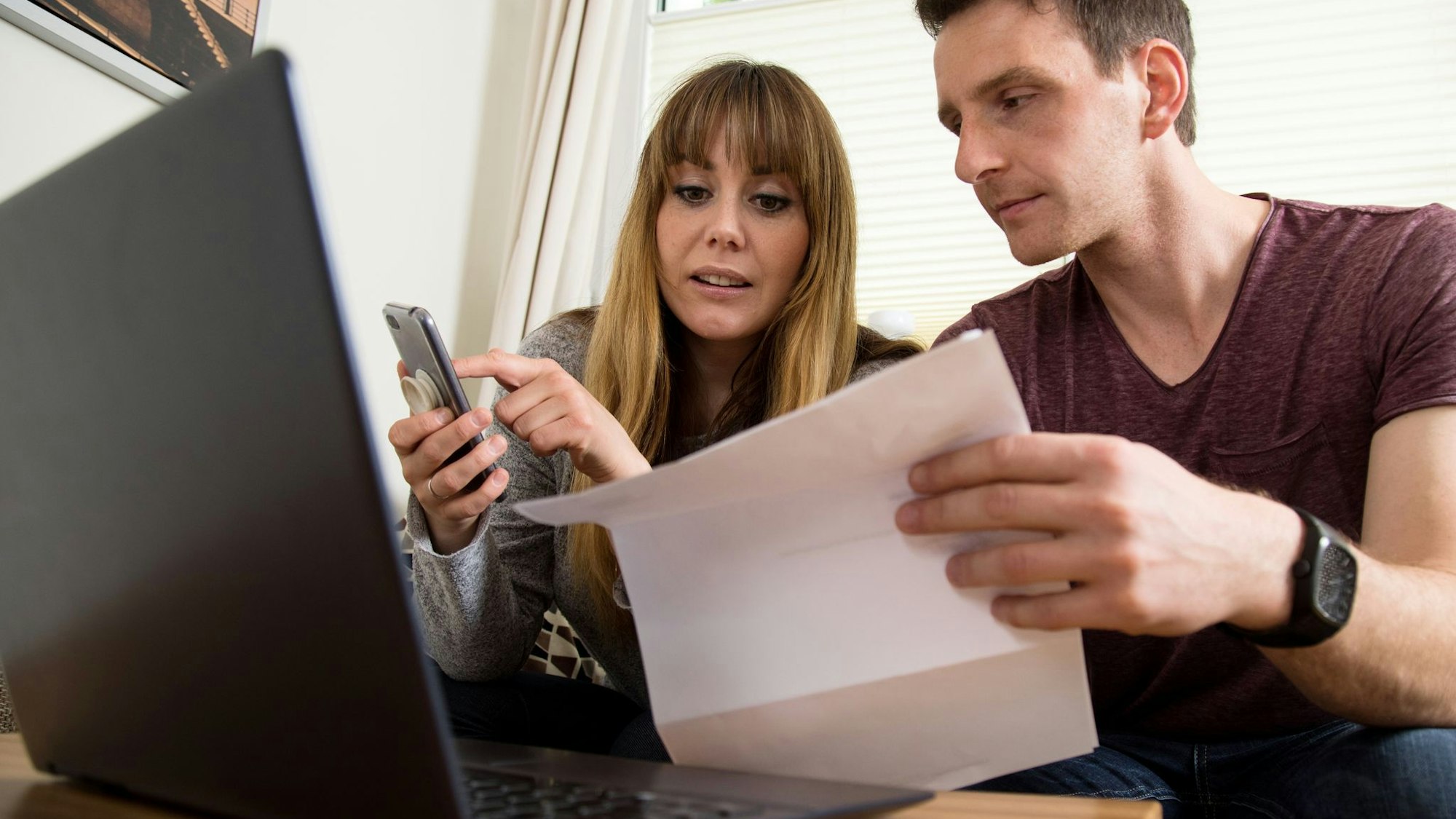 Ein Paar überprüft Unterlagen am PC
