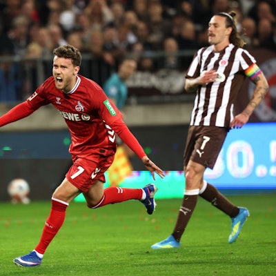 17.04.2026, Hamburg: Fußball, Männer: Bundesliga, FC St. Pauli - 1. FC Köln, 30. Spieltag, Millerntor-Stadion. Luca Waldschmidt (l, 1. FC Köln) jubelt nach einem 1:1 Ausgleichstreffer, während Jackson Irvine (FC. St. Pauli) zusieht. Foto: Christian Charisius/dpa - WICHTIGER HINWEIS: Gemäß den Vorgaben der DFL Deutsche Fußball Liga bzw. des DFB Deutscher Fußball-Bund ist es untersagt, in dem Stadion und/oder vom Spiel angefertigte Fotoaufnahmen in Form von Sequenzbildern und/oder videoähnlichen Fotostrecken zu verwerten bzw. verwerten zu lassen. +++ dpa-Bildfunk +++