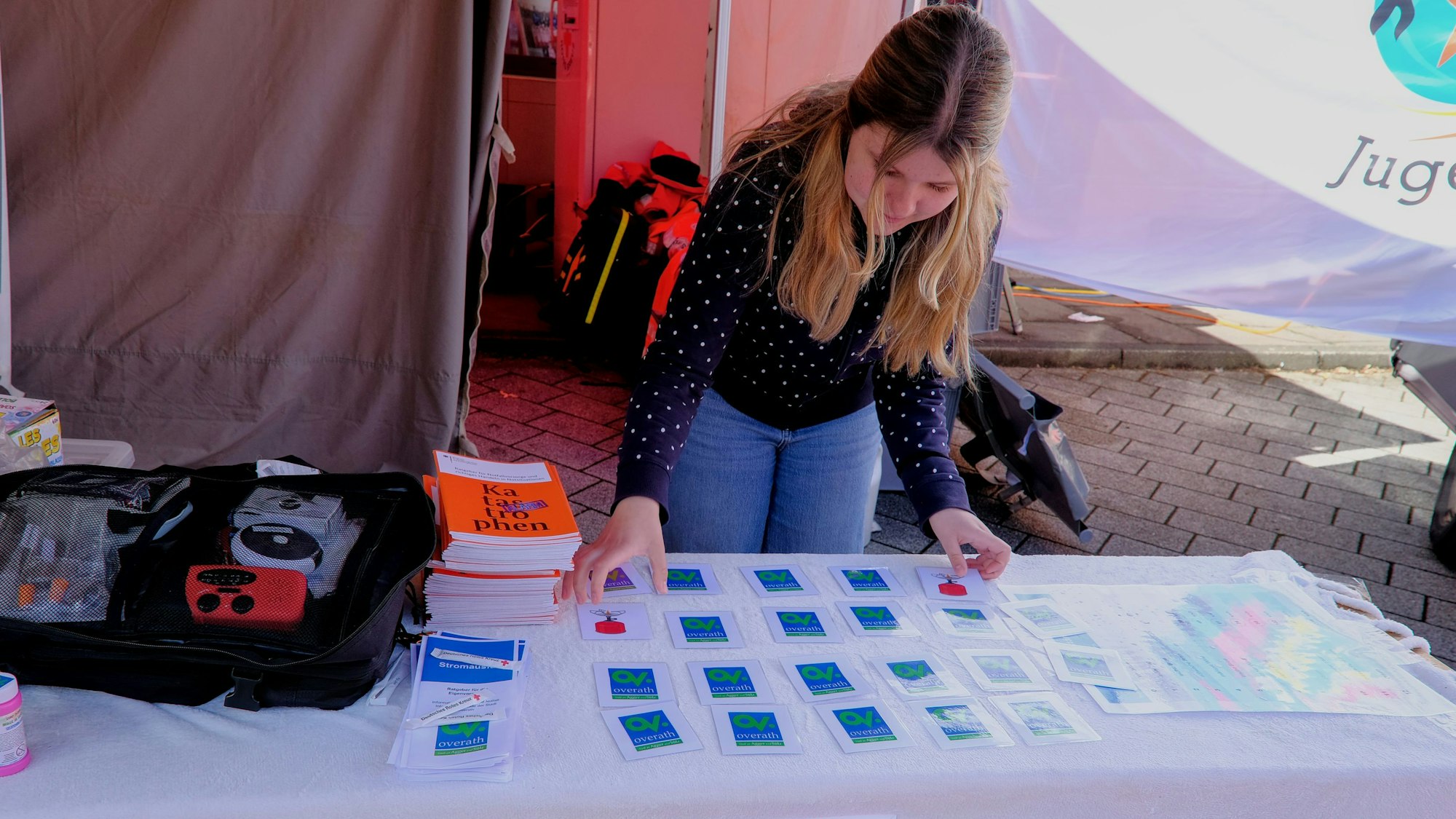 Eine Frau steht vor einem Tisch mit Memory-Spielkarten.