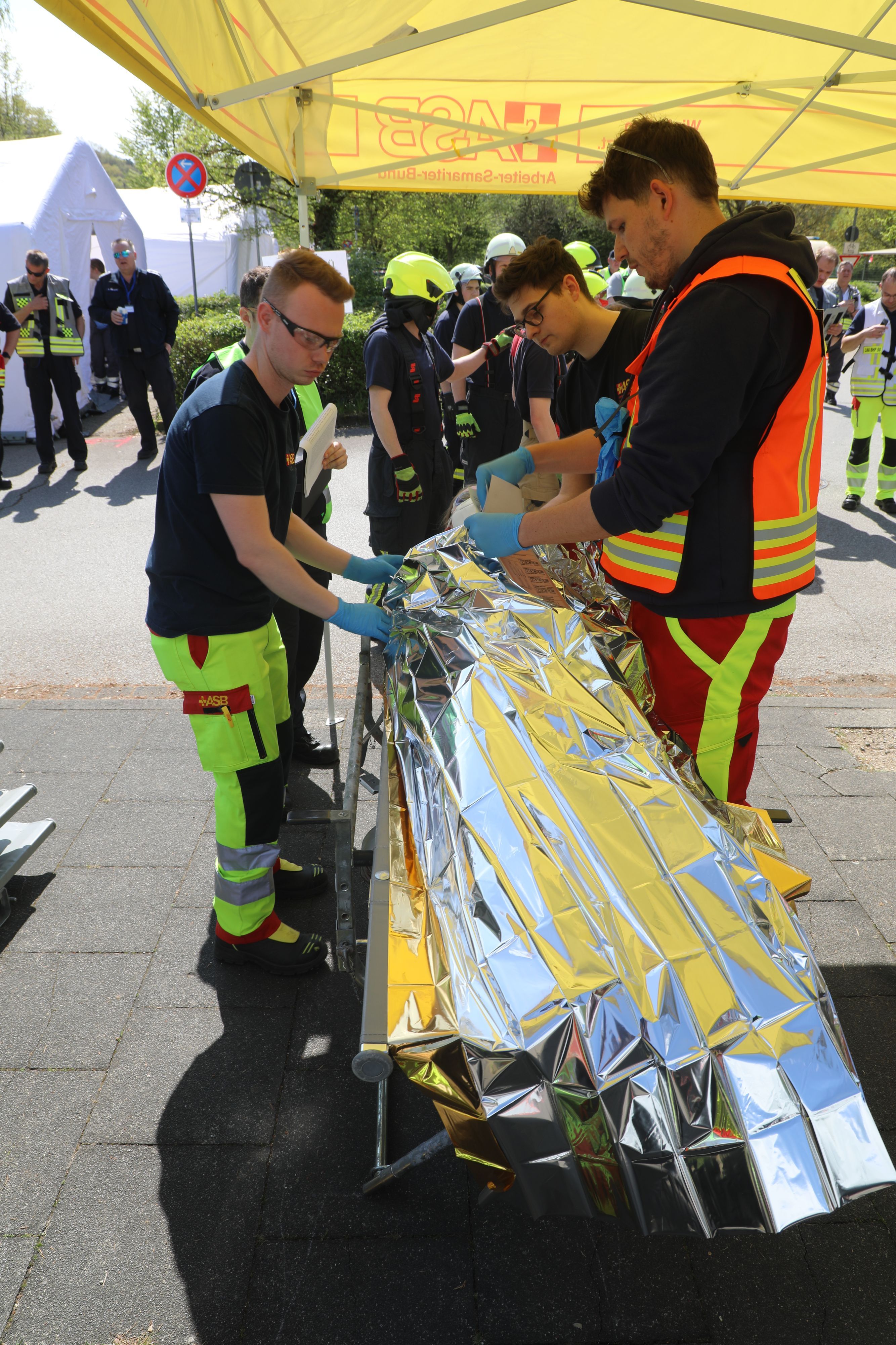 Ein Arzt und Rettungsassistenten versorgen und sichten eine Patientin bei der Großübung des Katastrophenschutzes in Overath.