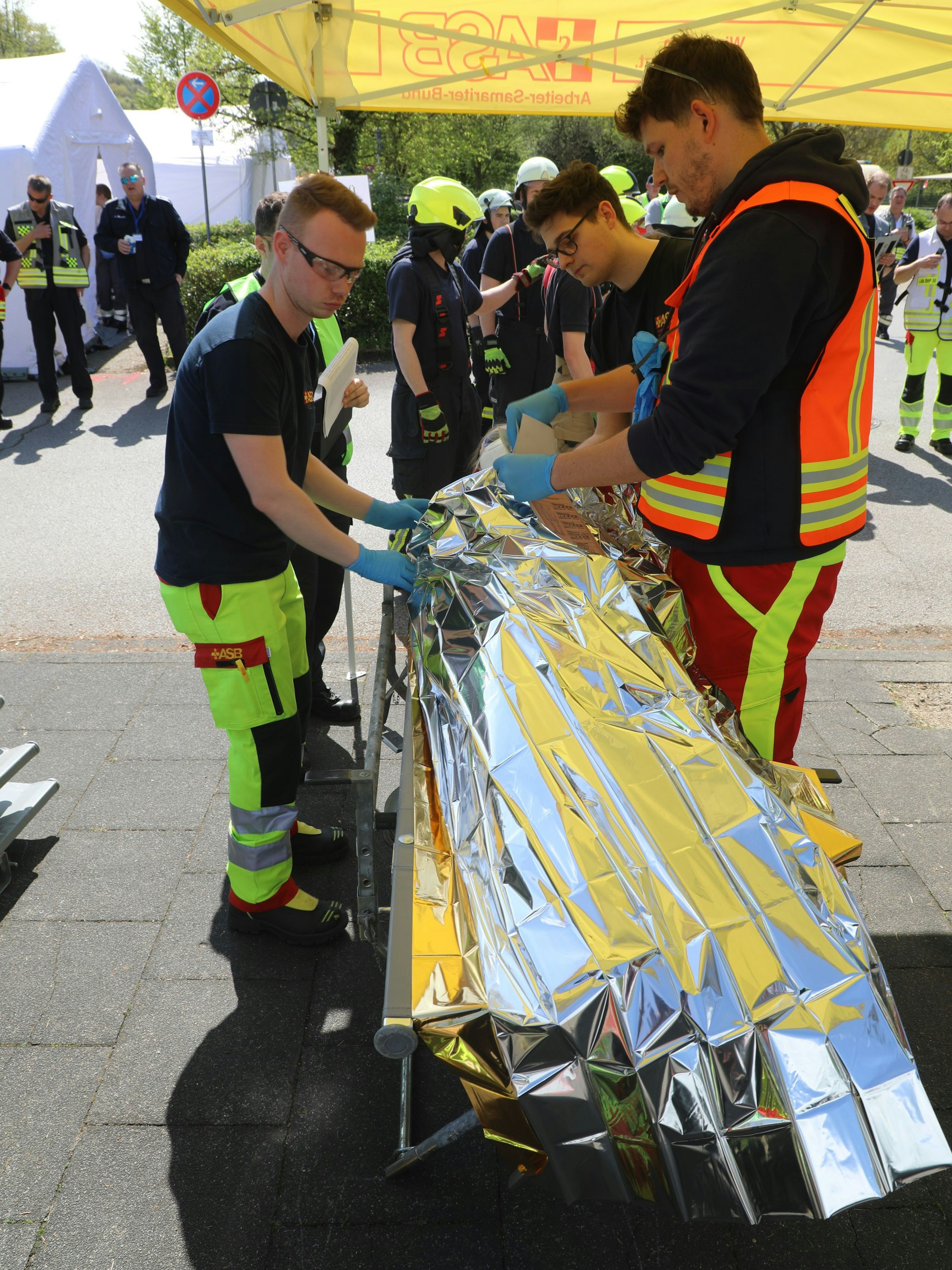 Ein Arzt und Rettungsassistenten versorgen und sichten eine Patientin bei der Großübung des Katastrophenschutzes in Overath.