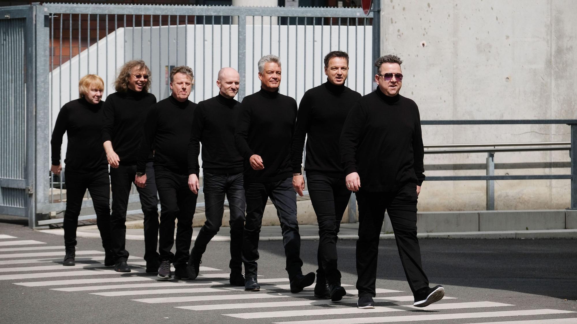 Mitglieder der Band Die Prinzen gehen über einen Zebrastreifen.