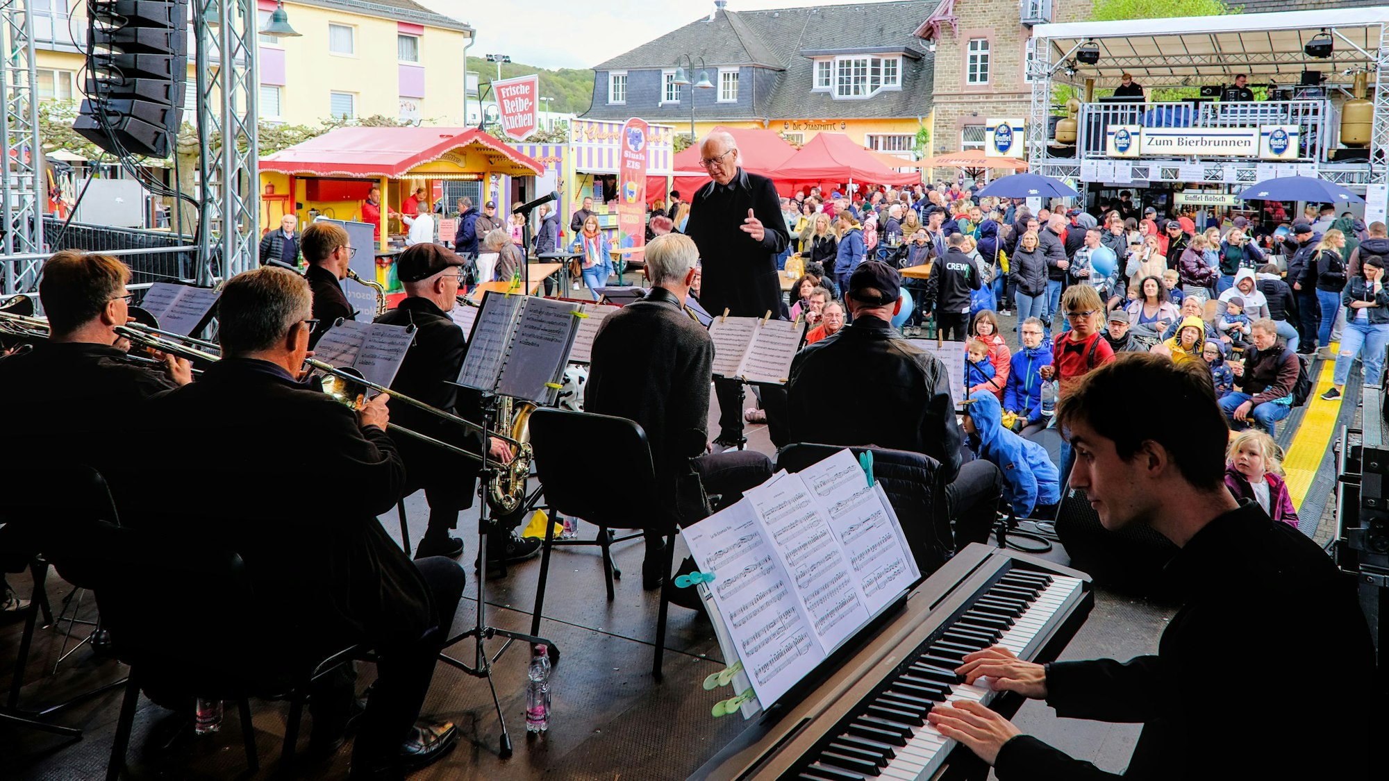 Auf der Bühne steht die Bigband Marialinden vor einem mit Menschen gefüllten Platz.