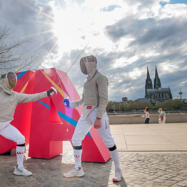 Zwei Fechter stehen vor einem überdimensionalen „Ja“ auf dem Kölner Rheinboulevard. So feierten die NRW-Olympiaplaner am Sonntag den positiven Ausgang der Ratsbürgerentscheide.