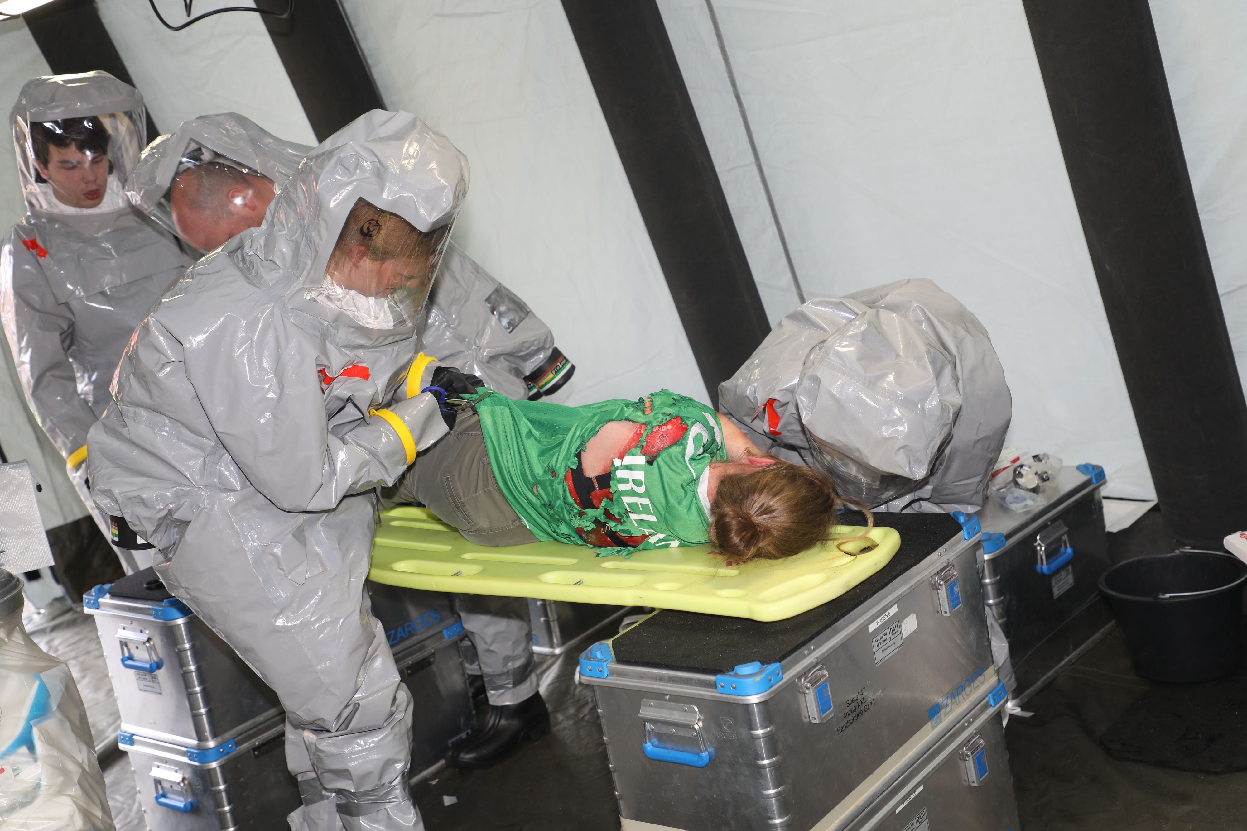 Vor der Dekontamination wird eine Patientin bei der Großübung des Katastrophenschutzes in Overath entkleidet, und Wunden werden mit wasserdichten Pflastern abgeklebt.