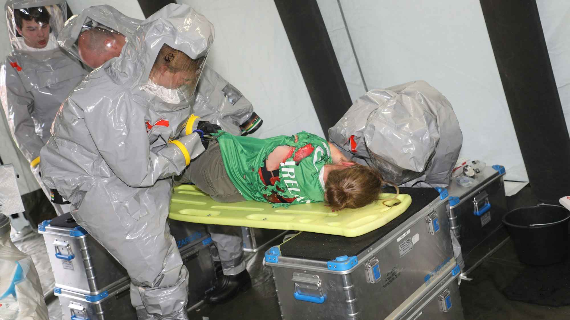 Vor der Dekontamination wird eine Patientin bei der Großübung des Katastrophenschutzes in Overath entkleidet, und Wunden werden mit wasserdichten Pflastern abgeklebt.