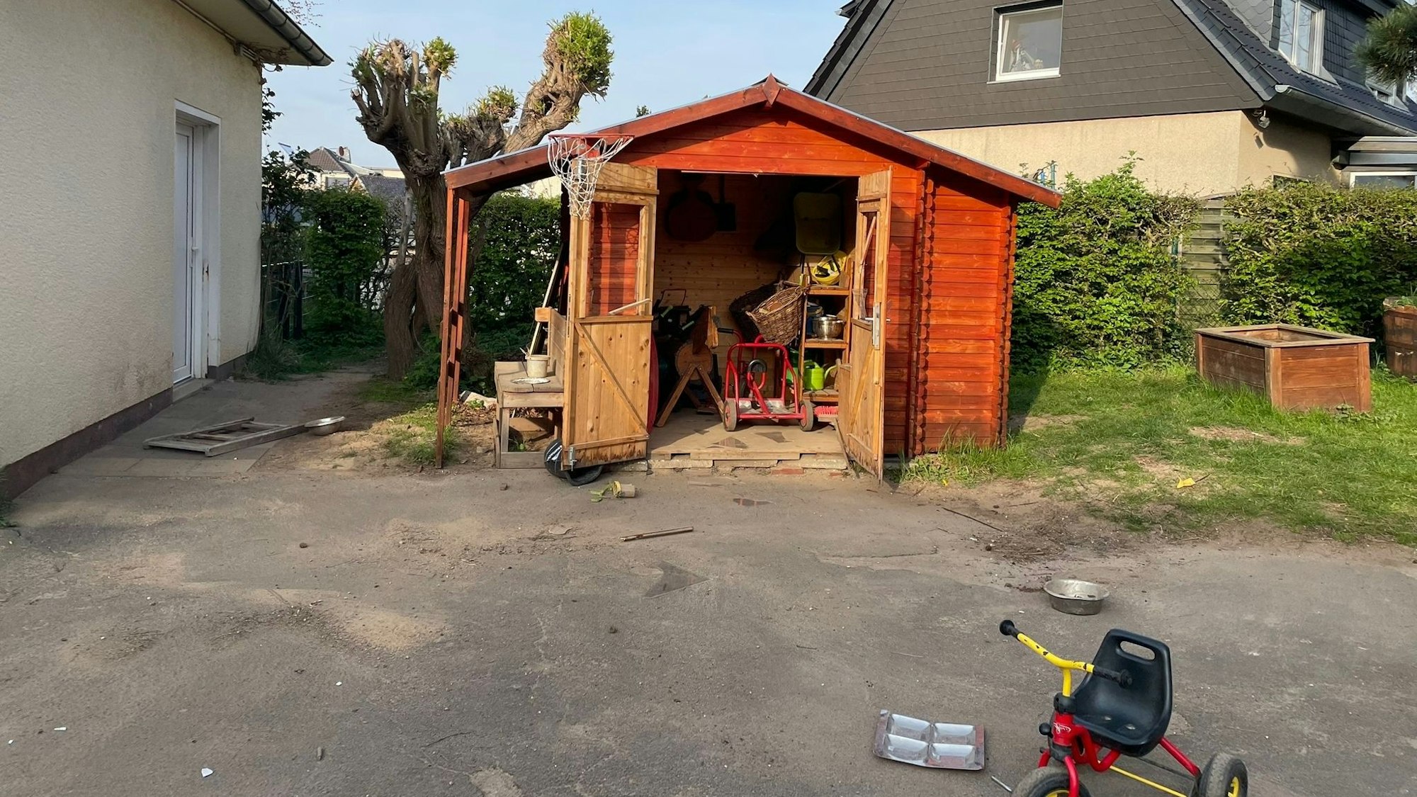 An einem Gartenhaus aus Holz wurden die Scheiben eingeschlagen, die Tür steht weit offen.