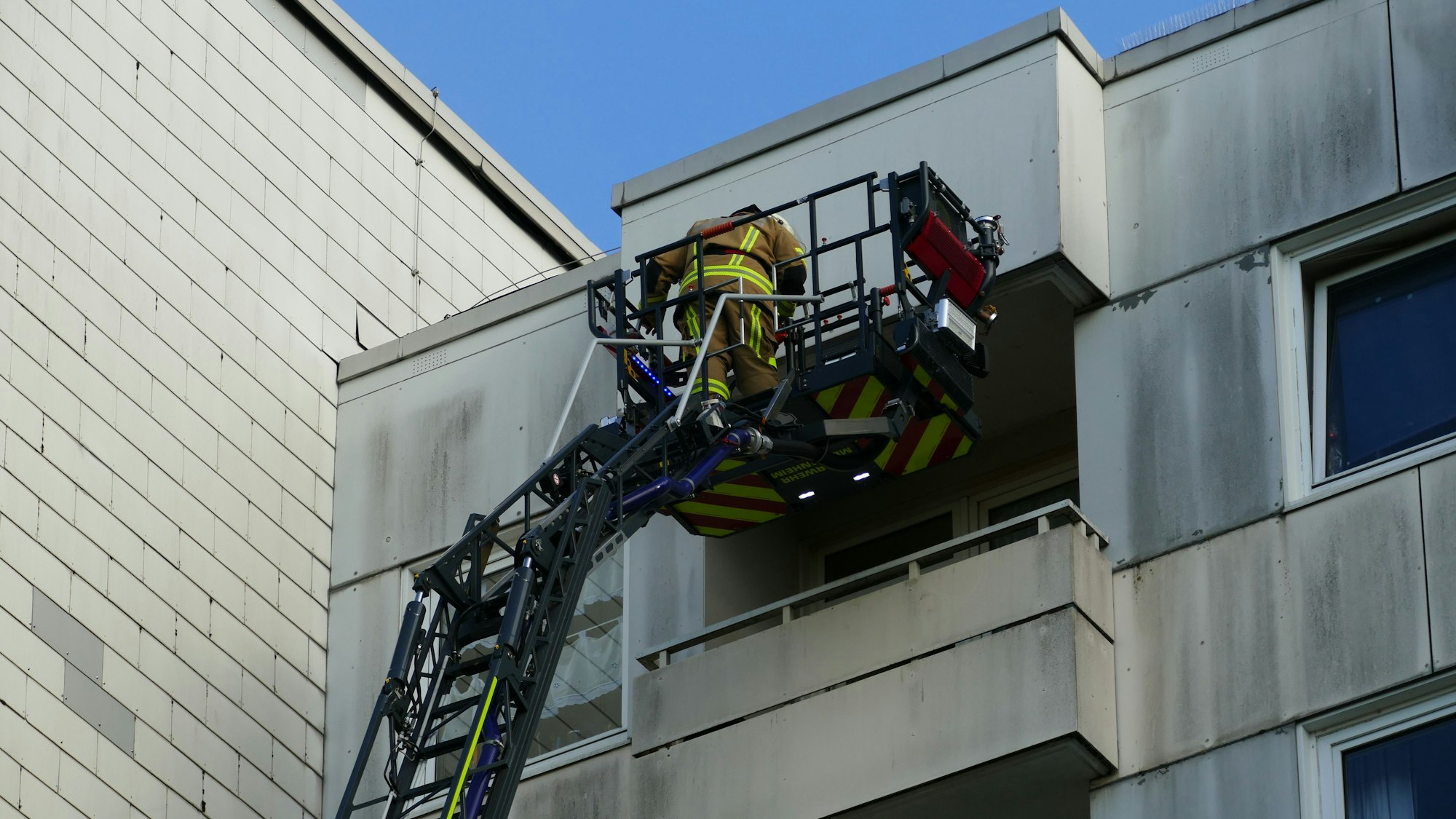 Die Feuerwehr holt Bewohnerinnen mit der Drehleiter aus ihrer Wohnung im achten Stock, um sie nicht durch das verrauchte Treppenhaus tragen zu müssen.