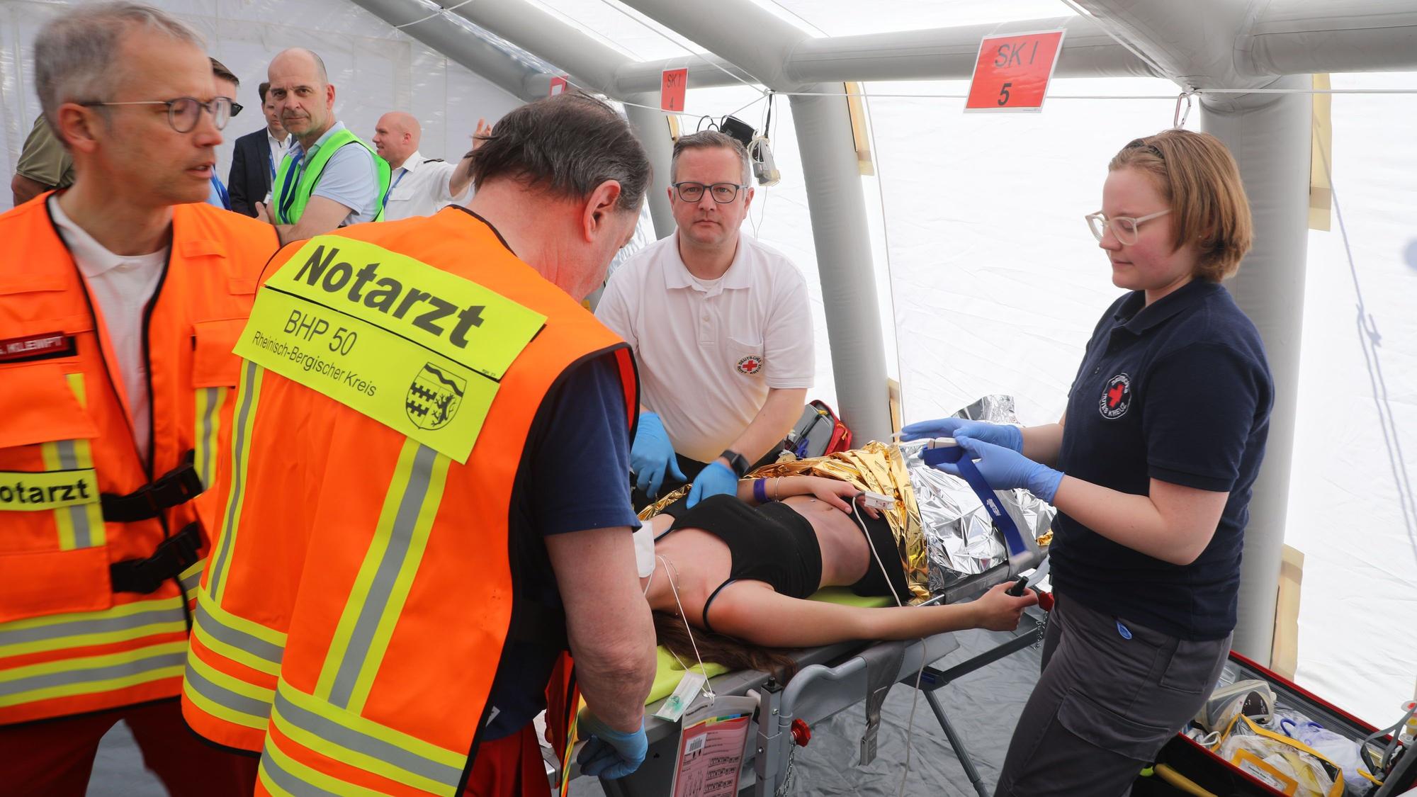 Ein Notarzt behandelt eine Verletzte bei der Großübung des Katastrophenschutzes in Overath.